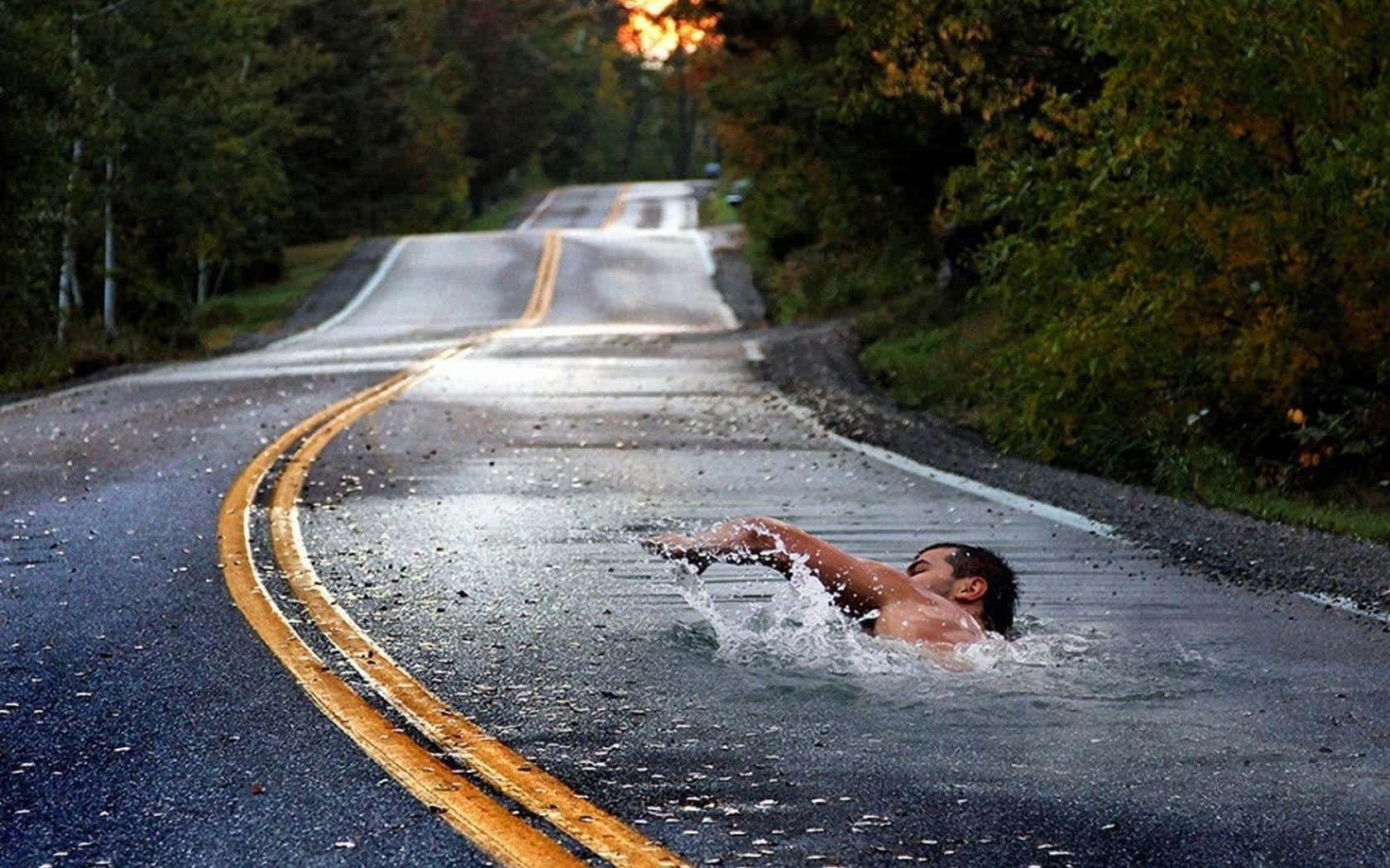 Swimming 桌布 壁紙 — 一名赤裸上身的男子在被水淹沒的森林道路上濺水而行，金色的夕陽光芒穿過樹林閃耀。