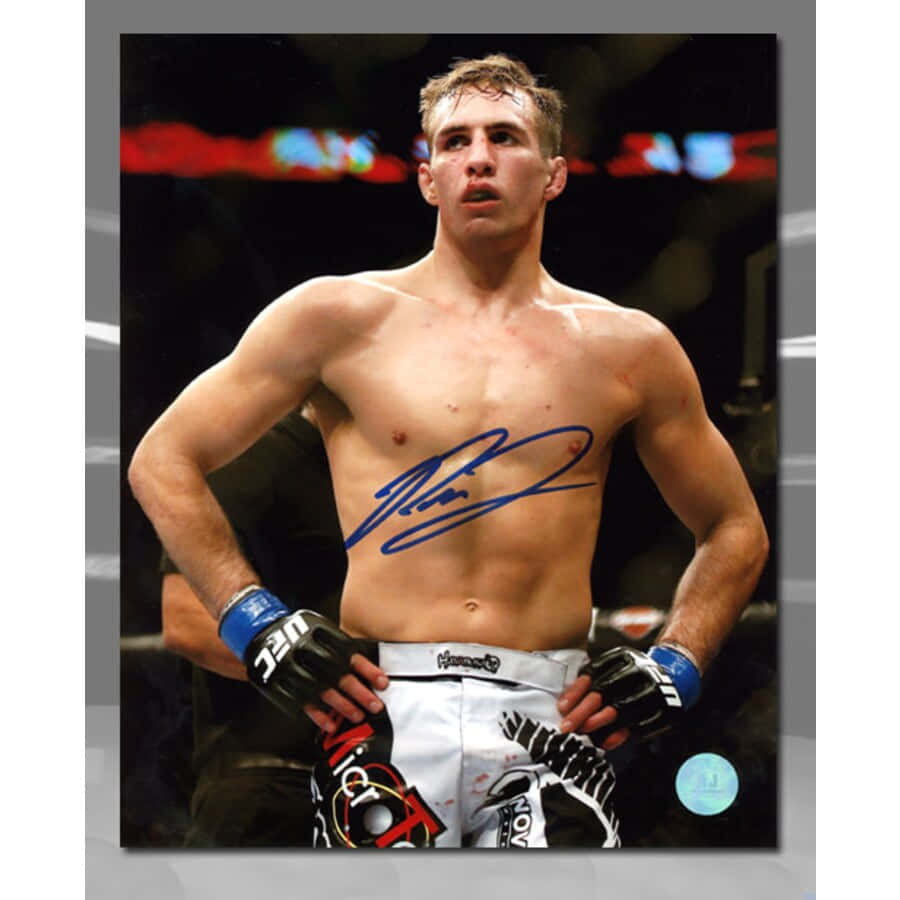 MMA 桌布 壁紙 — 一名赤裸上身的男性拳手站在擂台上，雙手叉腰，胸前有一道簽名。
