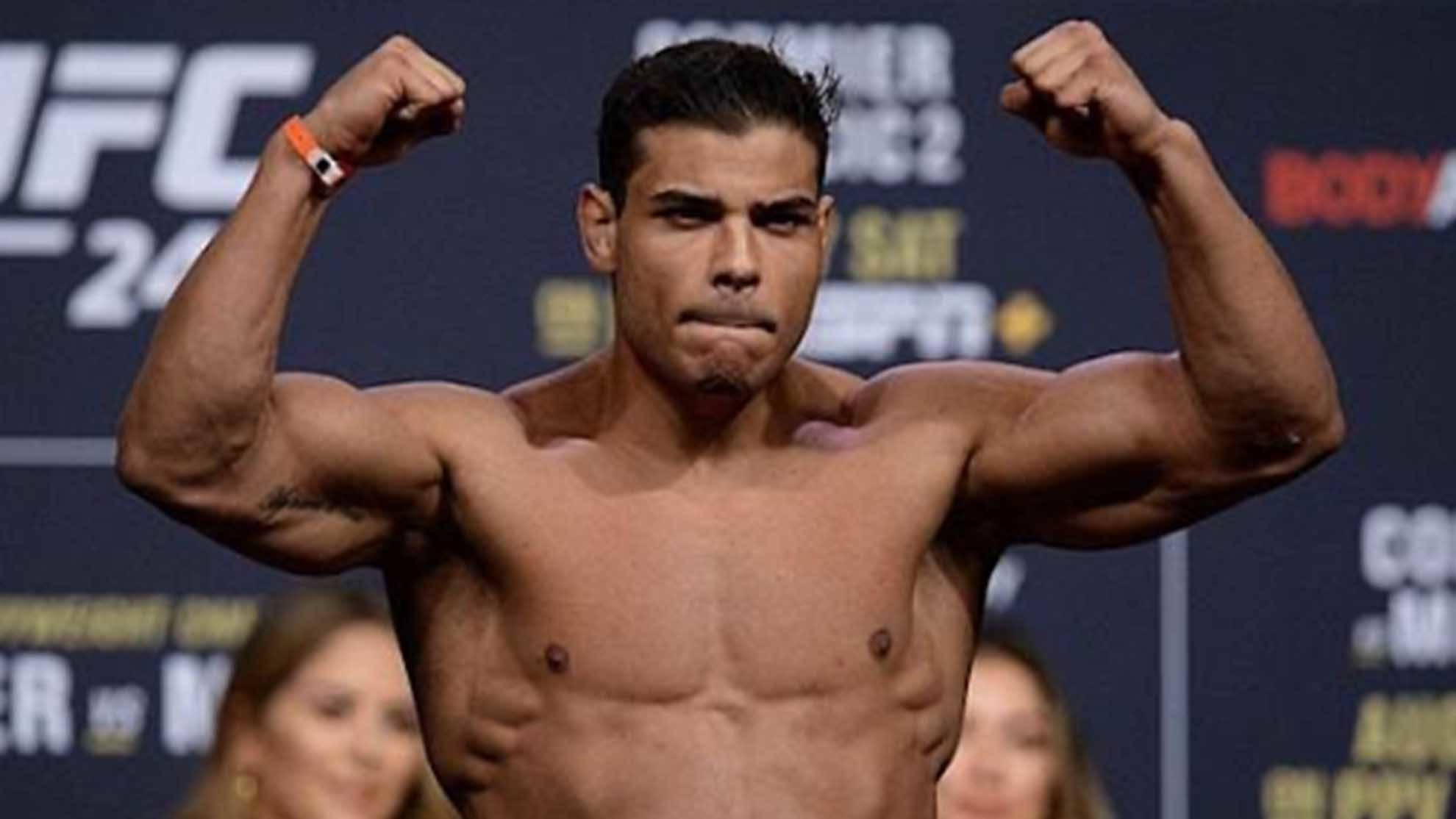 UFC 桌布 壁紙 — 一名赤裸上身的肌肉發達拳手在帶有品牌背景的UFC稱重活動中彎曲雙臂。