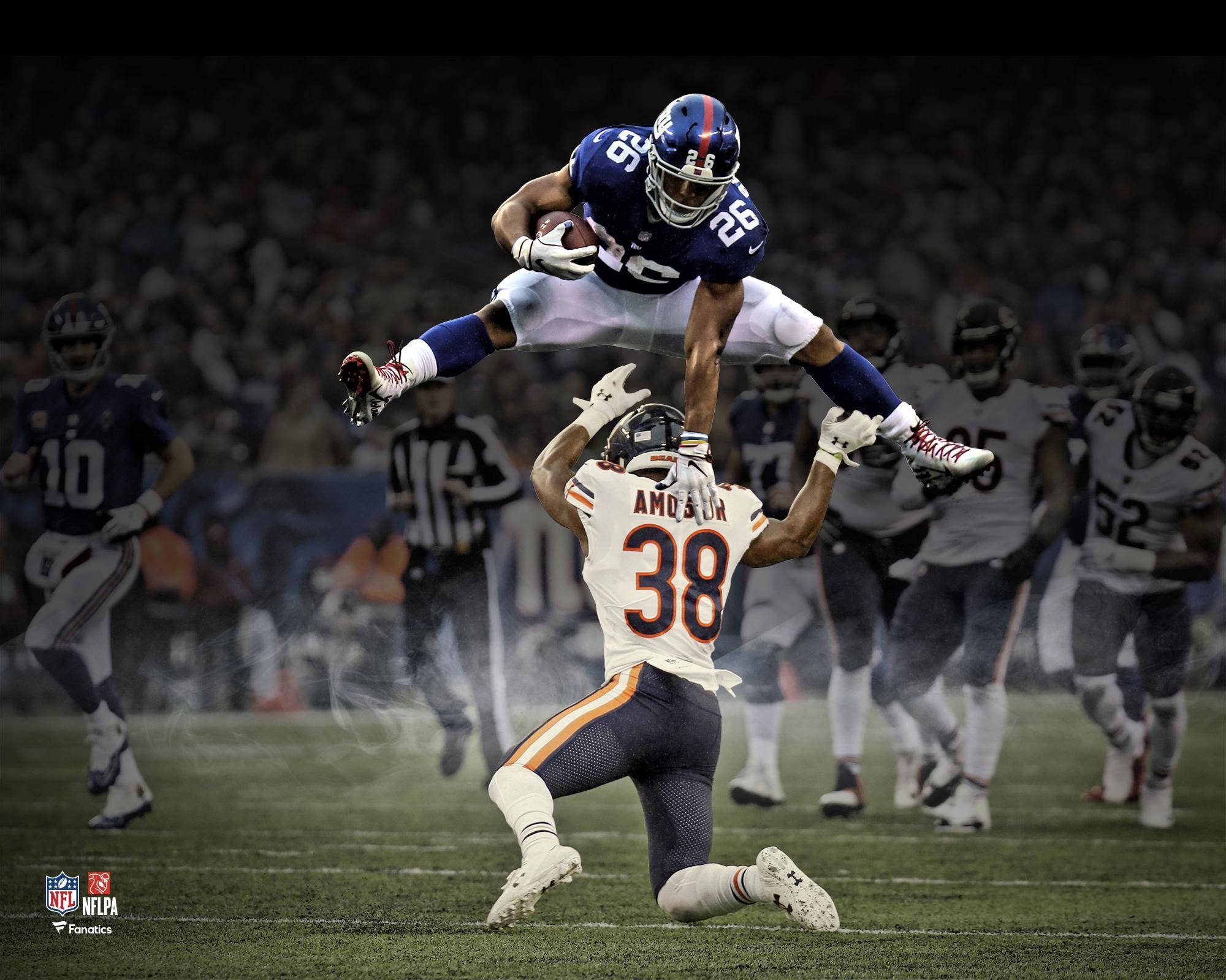 Saquon Barkley 桌布 壁紙 — 一名足球員在夜間比賽中，在球場燈光下高高躍過防守球員接球。