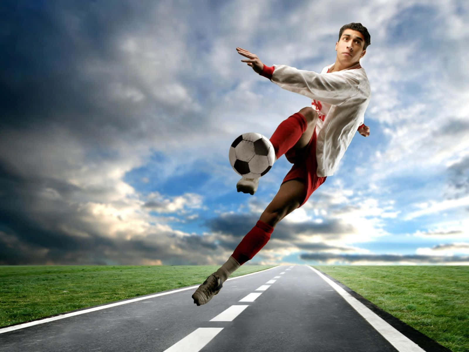 3d Sports 桌布 壁紙 — 一名足球員在戲劇性的多雲天空下，於道路上空中踢球。
