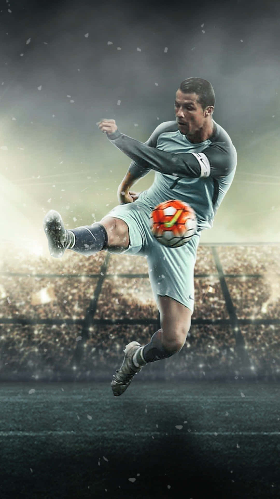 Soccer iPhone 桌布 壁紙 — 一名足球員在球場上，在戲劇性的燈光和飄雪中凌空踢球。