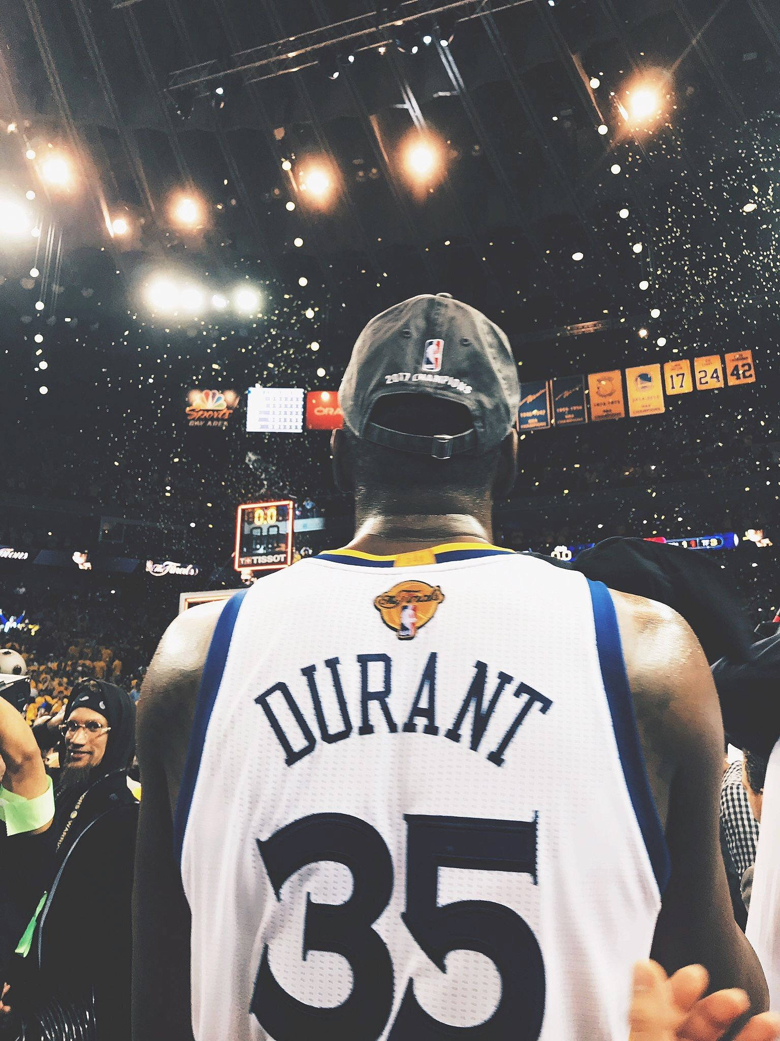 凱文·杜蘭特 桌布 壁紙 — 一名身穿 'DURANT 35' 球衣的籃球運動員背對鏡頭站立，在擠滿觀眾的場館中，彩紙紛飛。