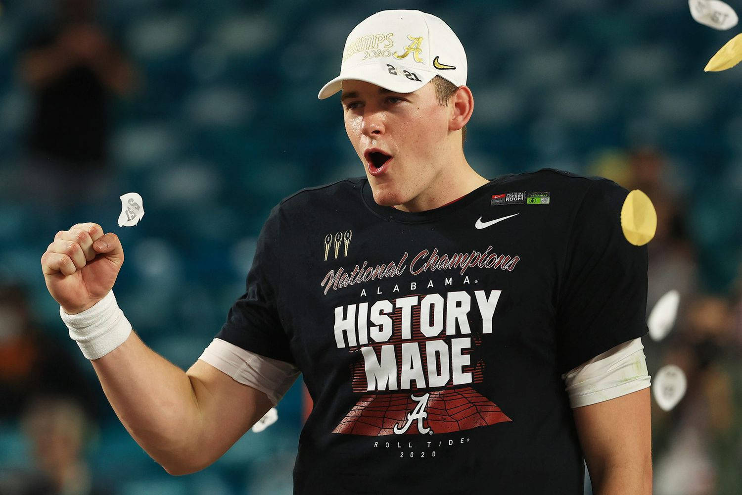 Mac Jones 桌布 壁紙 — 一名身穿「National Champions」球衣的歡欣足球員在體育場內慶祝，周圍飄揚著五彩紙屑。