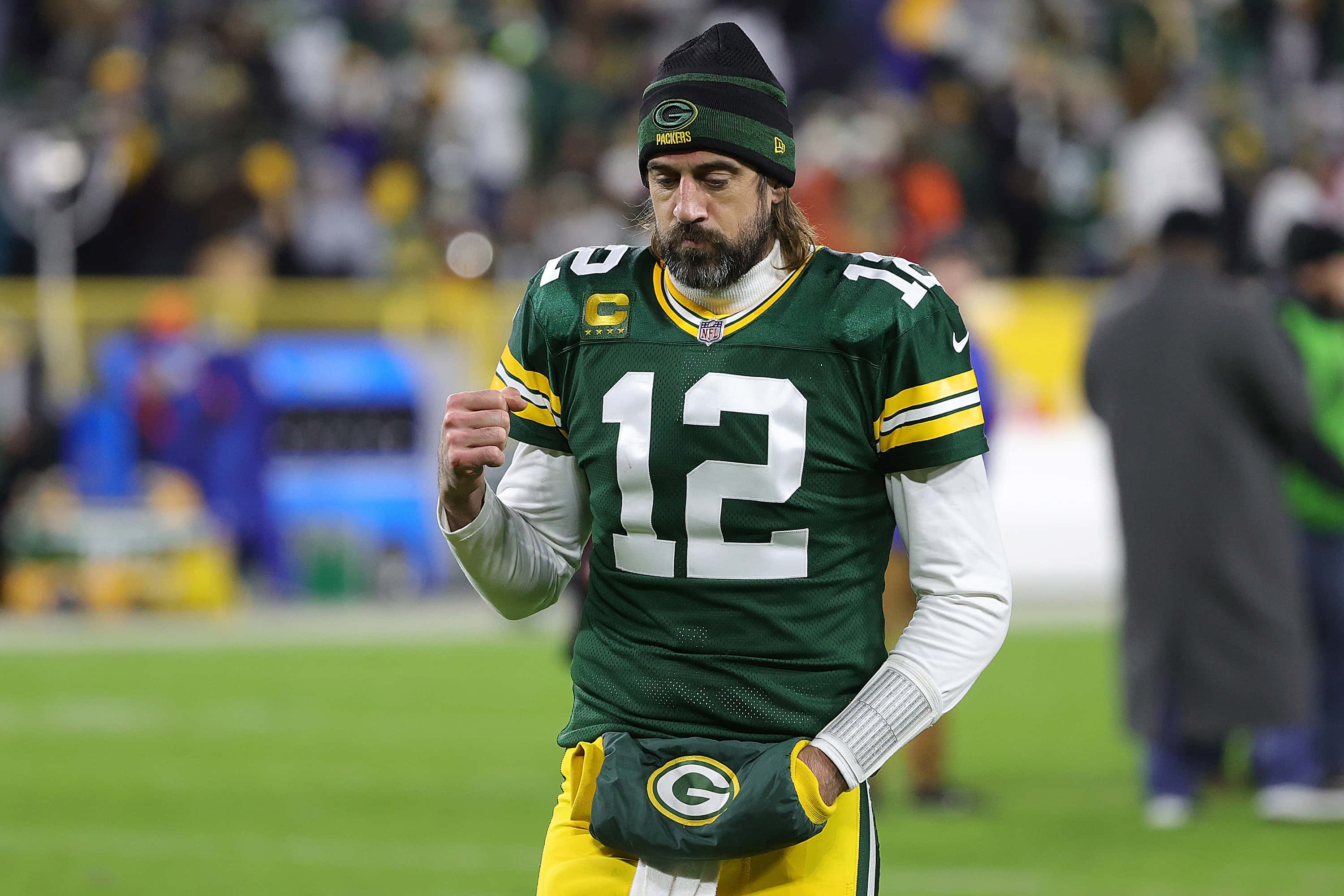 Aaron Rodgers 桌布 壁紙 — 一名身穿12號球衣的綠灣包裝工美式足球員在比賽中帶著專注的表情走進球場。