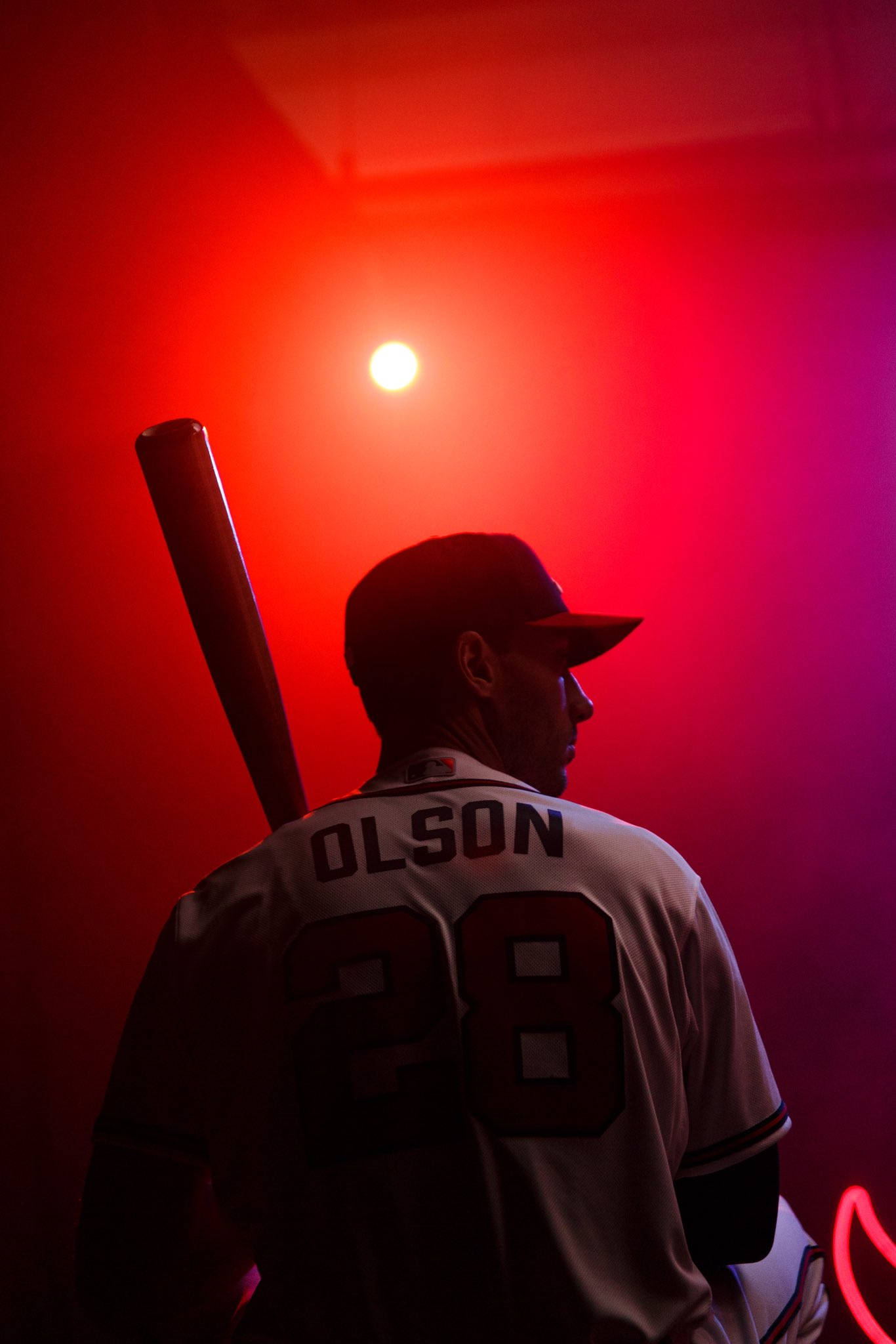 Matt Olson 桌布 壁紙 — 一名身穿28號球衣名叫Olson的棒球選手，在戲劇性的紅光下以剪影姿態手持球棒站立。
