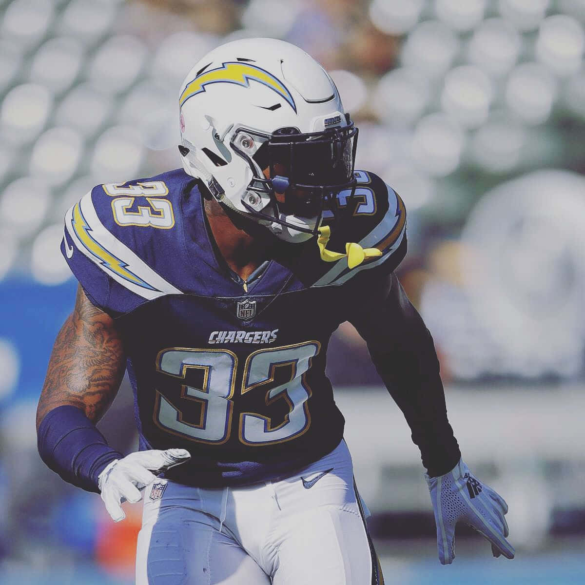 Chargers美式足球員33號在日落比賽中在場上奔跑。 — NFL GIF 壁紙