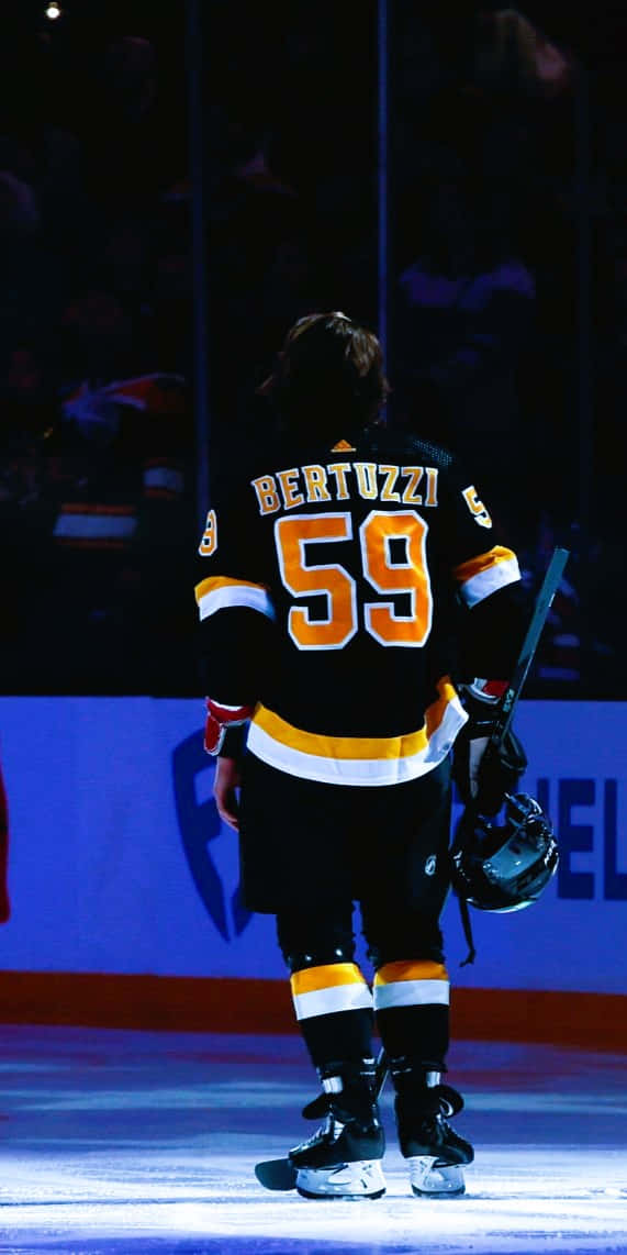 Tyler Bertuzzi 桌布 壁紙 — 一名身穿59號球衣的冰上曲棍球運動員獨自站在冰場上，手持球棍和頭盔。