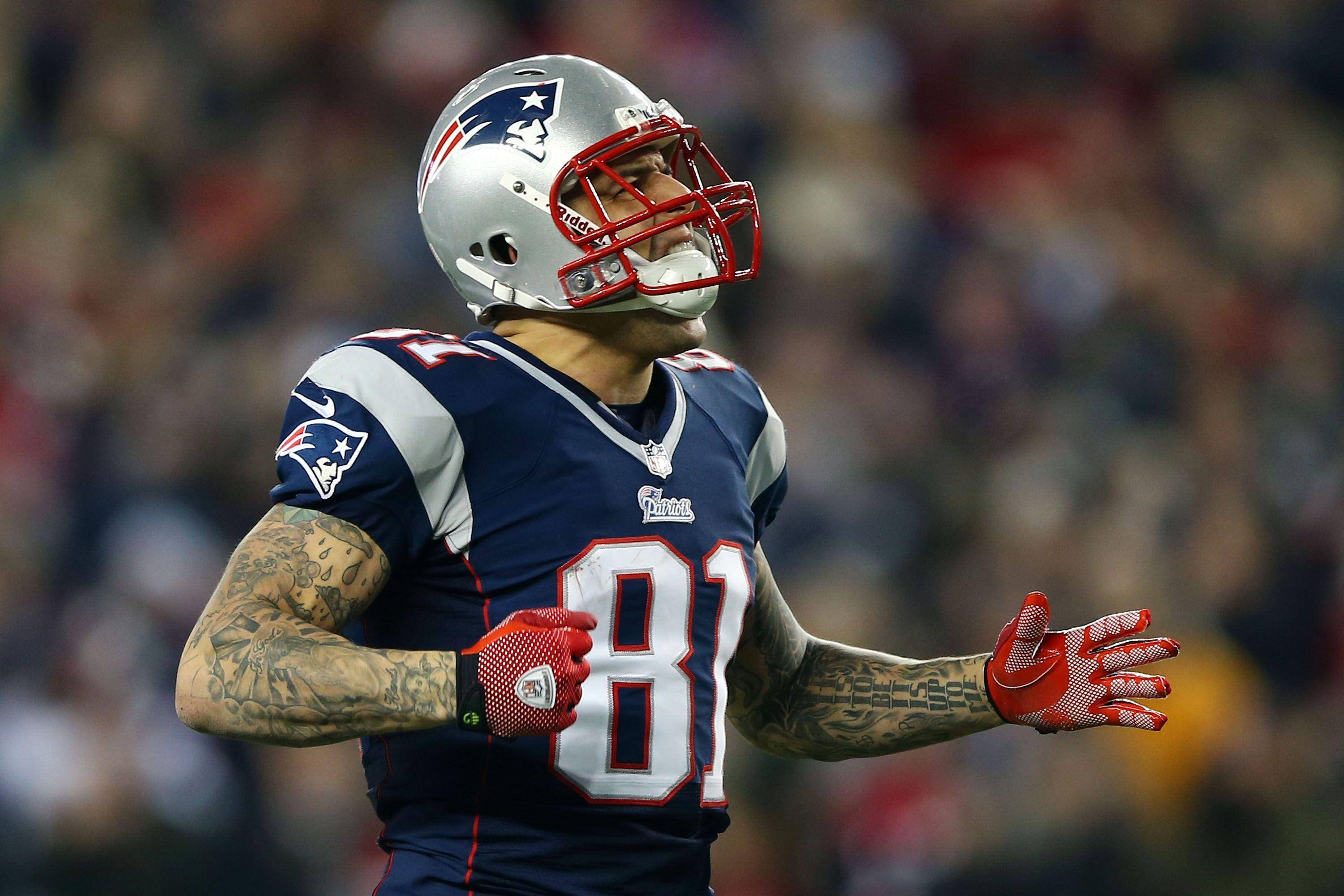NFL Players 桌布 壁紙 — 一名身穿81號球衣的新英格蘭愛國者隊美式足球員在球場燈光下比賽時張開雙臂做手勢。
