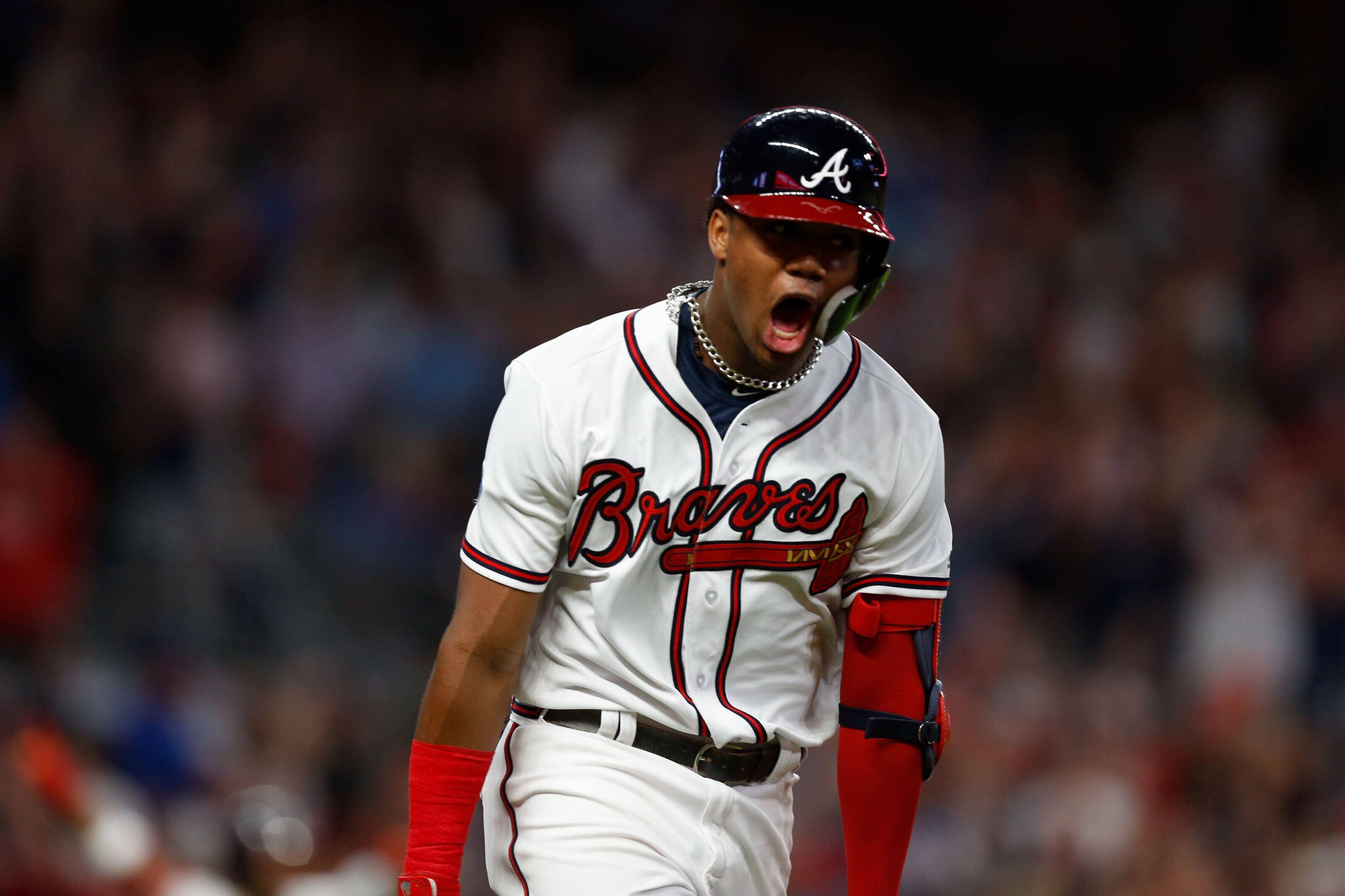 Acuna 桌布 壁紙 — 一名身穿Braves球衣的棒球選手在夜間比賽中，於球場燈光下發出勝利的怒吼。