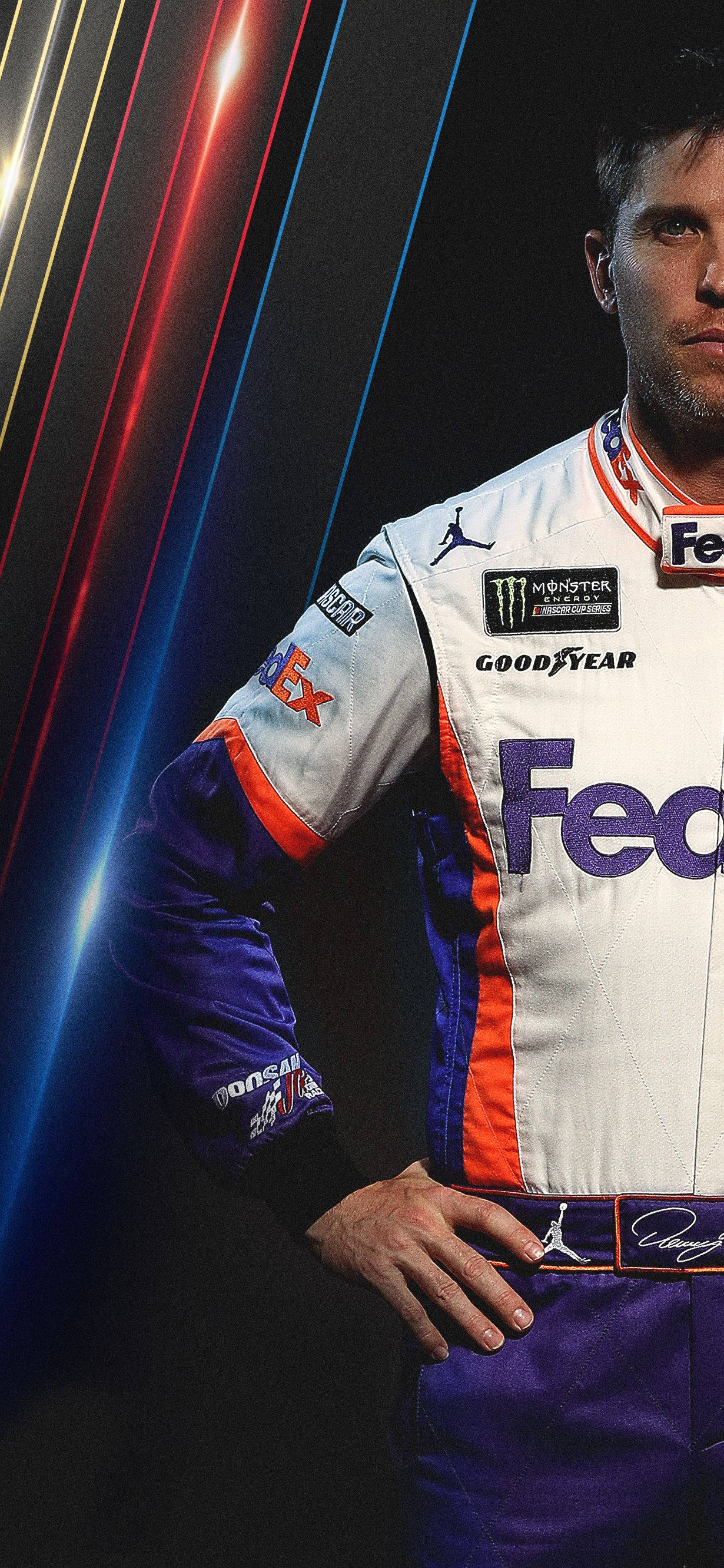 Denny Hamlin 桌布 壁紙 — 一名身穿FedEx賽車服的賽車手自信地站在黑暗背景前，背景有霓虹燈光條紋。