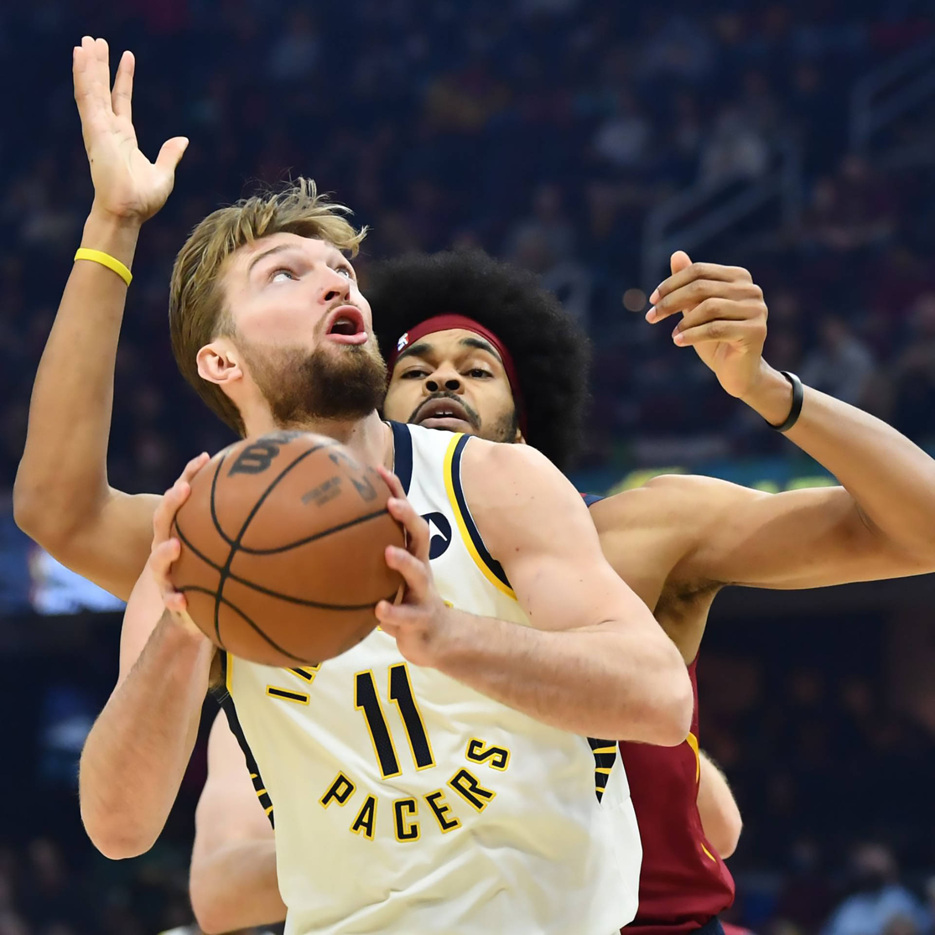 domantas sabonis 桌布 壁紙 — 一名身穿Pacers球衣的籃球運動員在對手緊密防守下猛烈地向籃框切入。