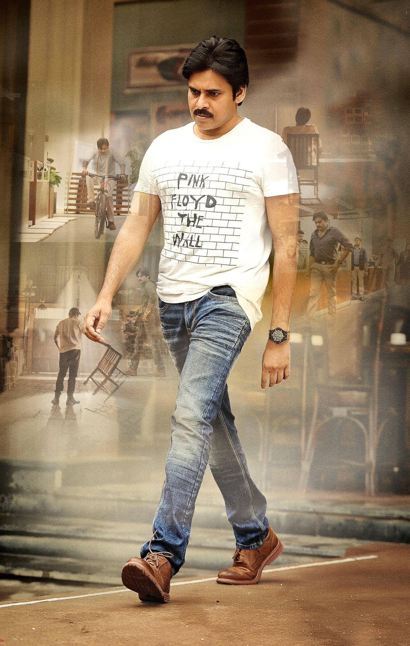 Pawan Kalyan 桌布 壁紙 — 一名身穿Pink Floyd T恤和牛仔褲的男子自信地走過煙霧瀰漫的城市小巷，背景有層疊的半透明場景。