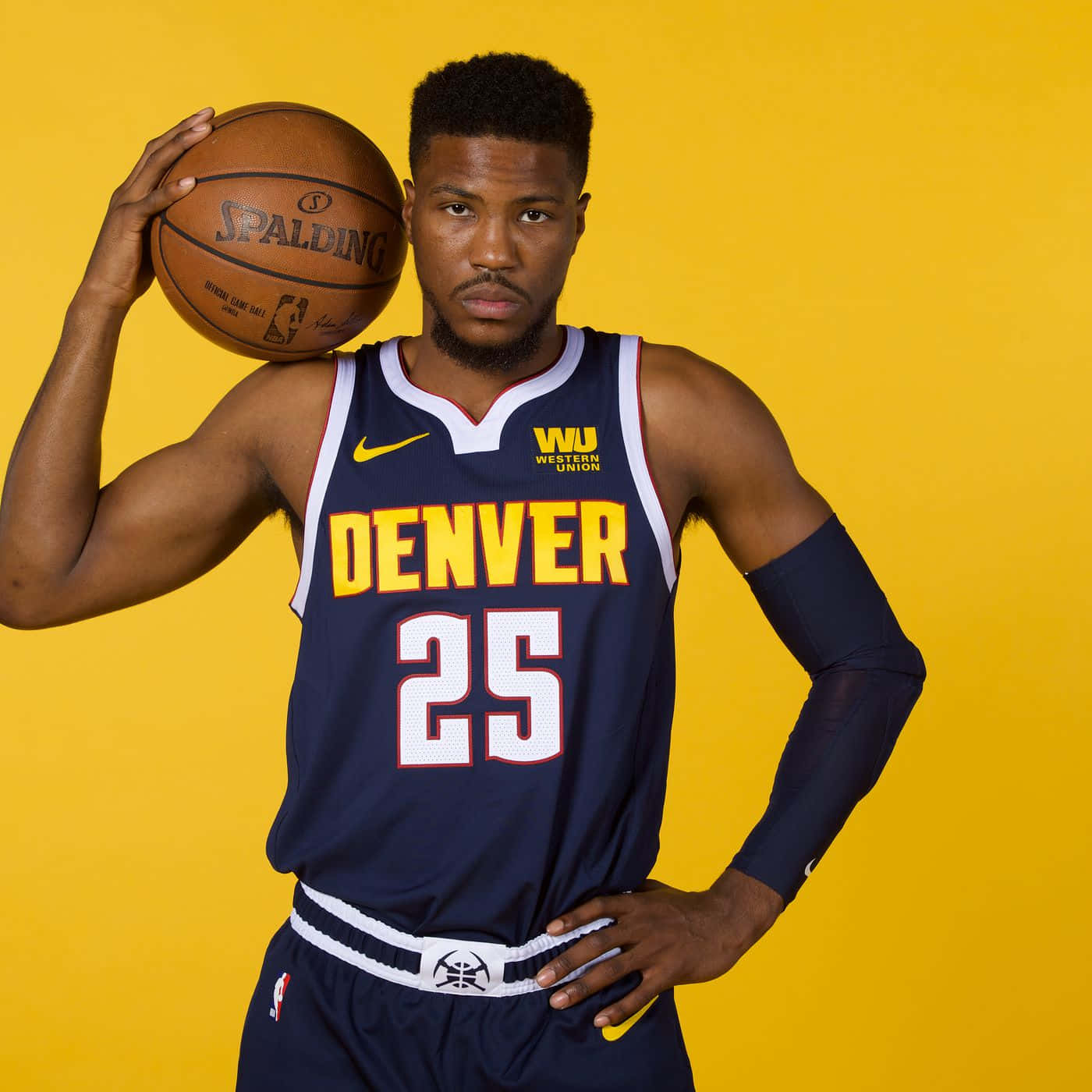 身穿丹佛球衣的籃球運動員在黃色背景前拿著籃球。 — NBA 壁紙