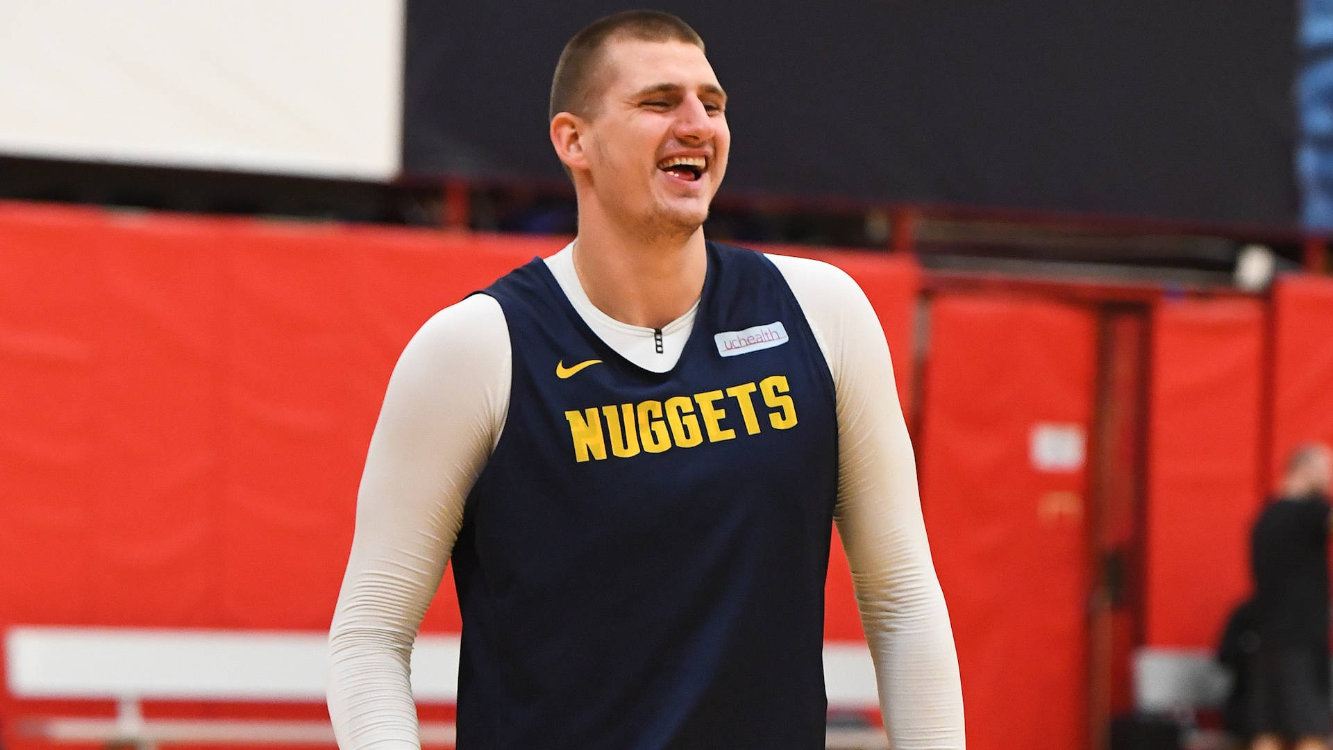 Jokic 桌布 壁紙 — 一名身穿丹佛金塊練習球衣的籃球運動員在室內訓練時開懷大笑。