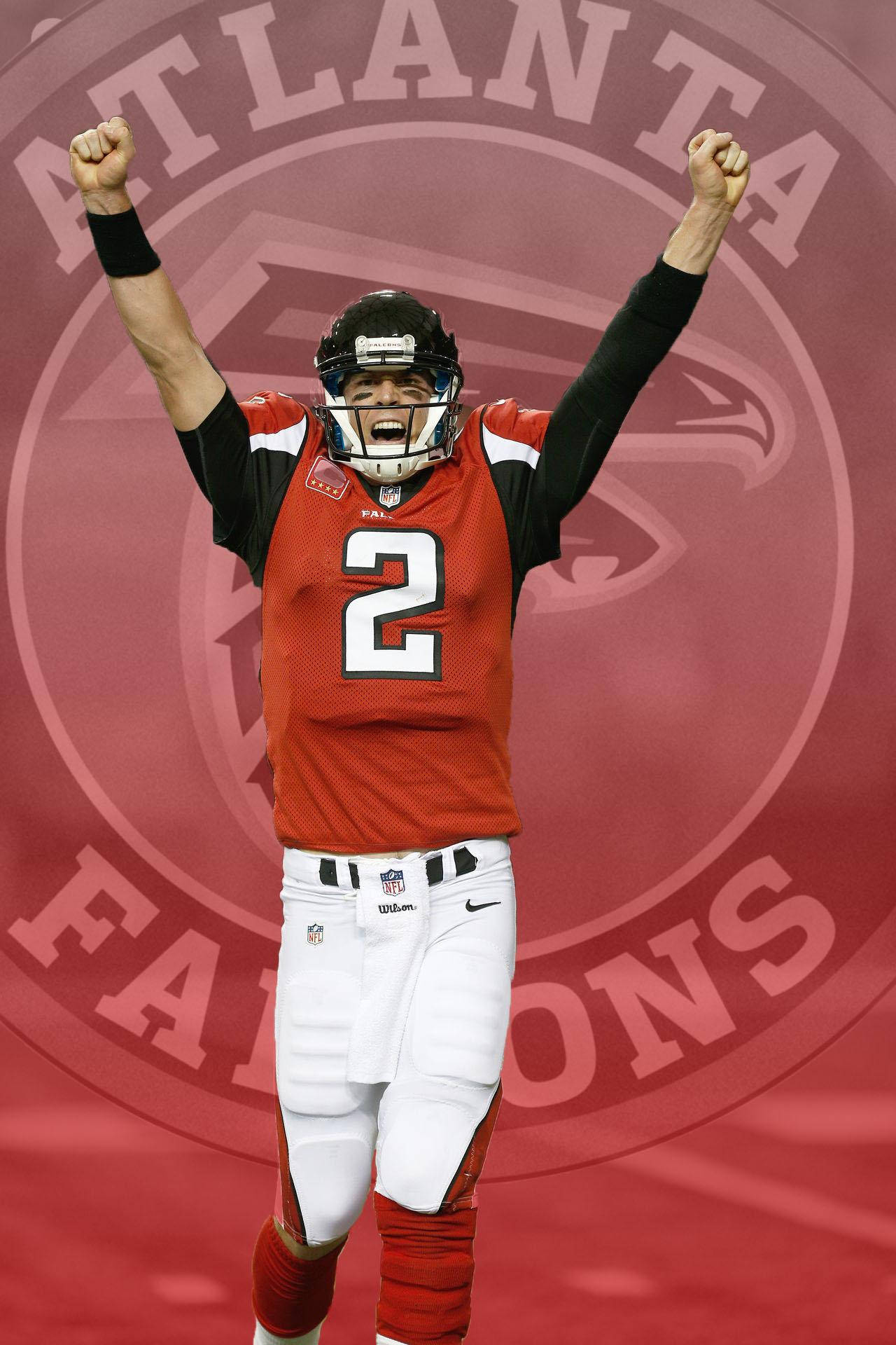Matt Ryan 桌布 壁紙 — 一名身穿亞特蘭大獵鷹隊紅黑色裝備的美式足球員在球隊標誌背景下舉起拳頭慶祝。