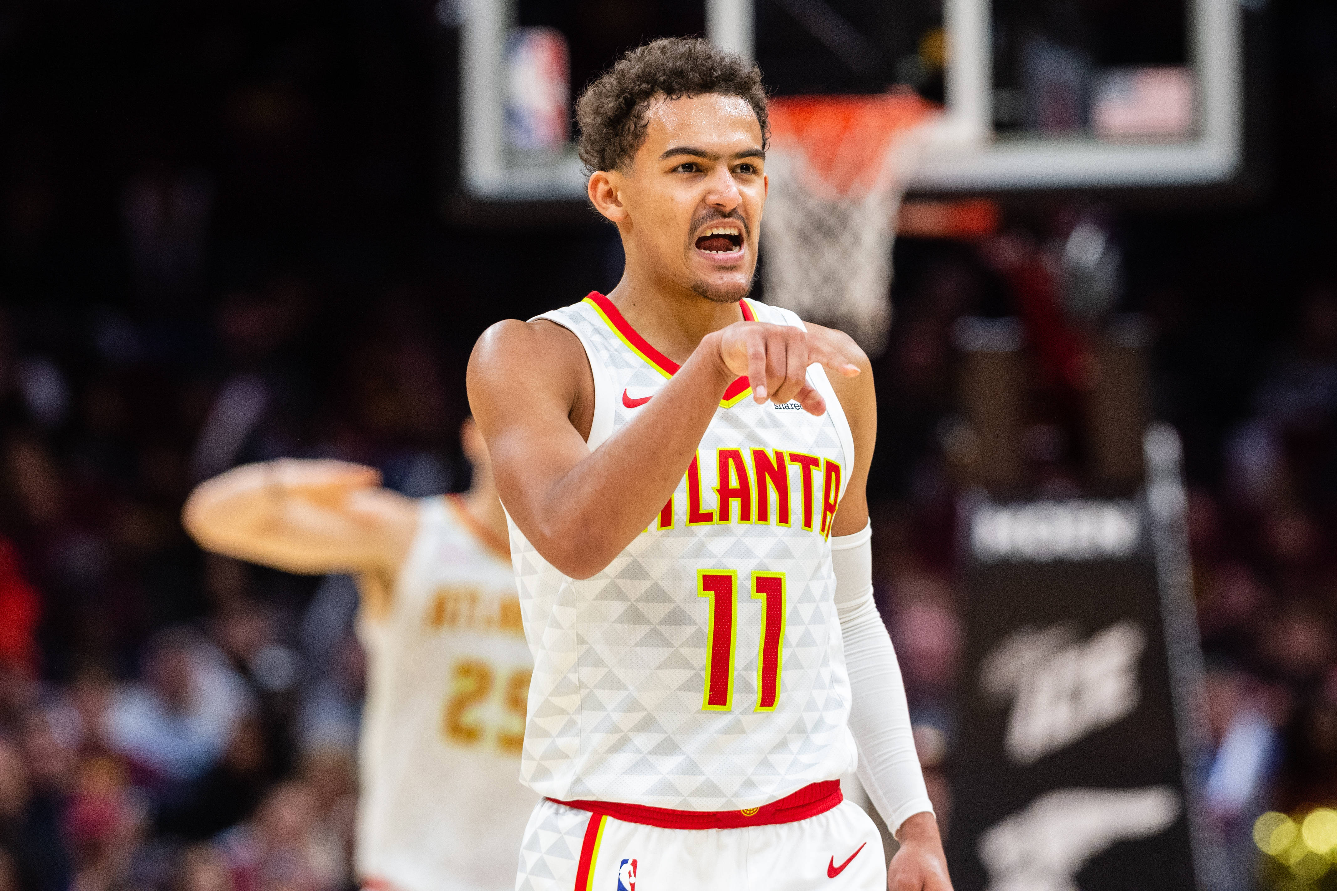 Hawks 桌布 壁紙 — 一名身穿亞特蘭大球衣的籃球運動員在明亮的場館燈光下，在比賽中激烈地喊叫和指點。