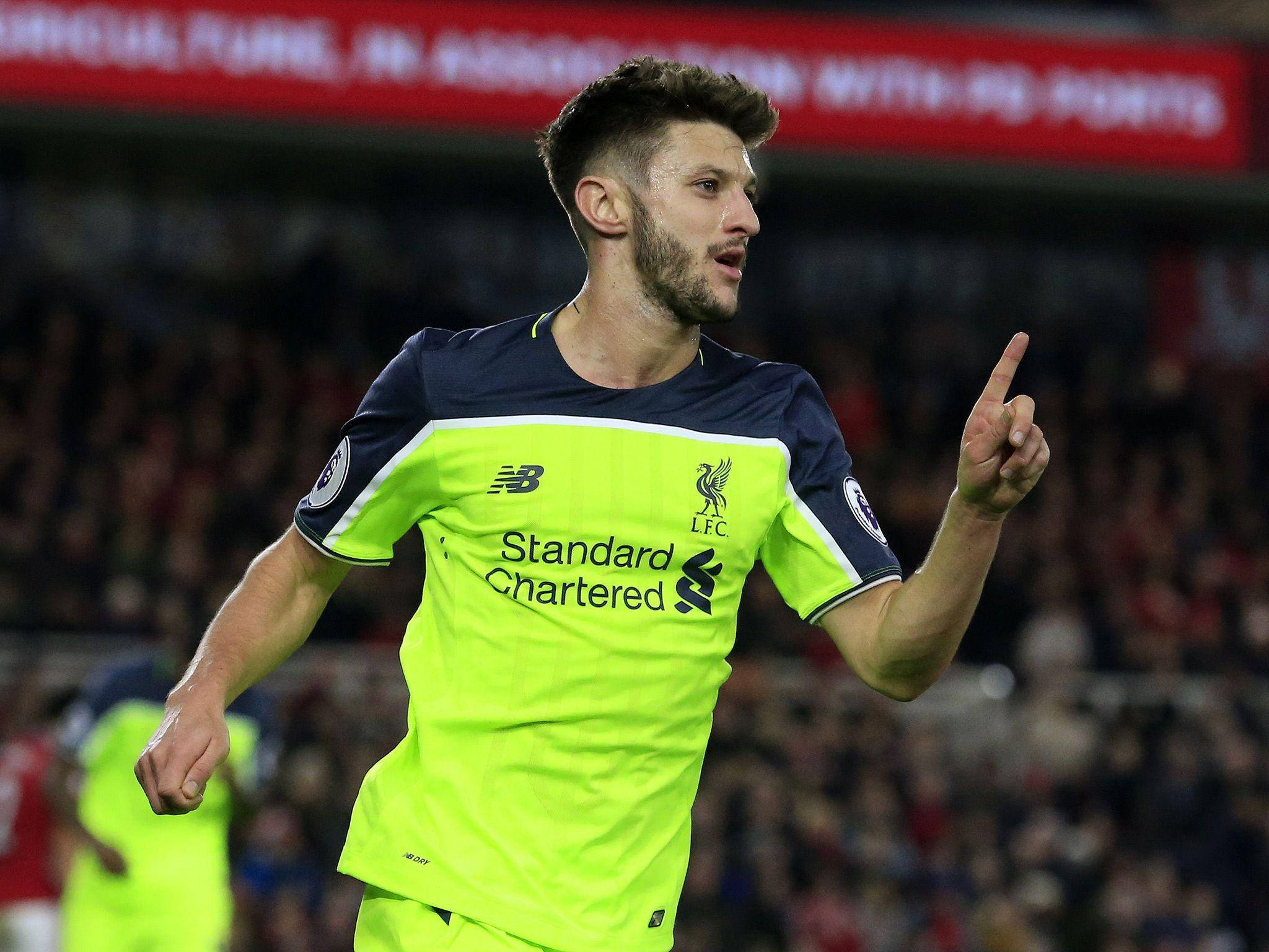 Liverpool Fc 桌布 壁紙 — 一名身穿亮眼螢光綠色利物浦球衣的足球員，在模糊的球場人群背景下舉起手指慶祝。