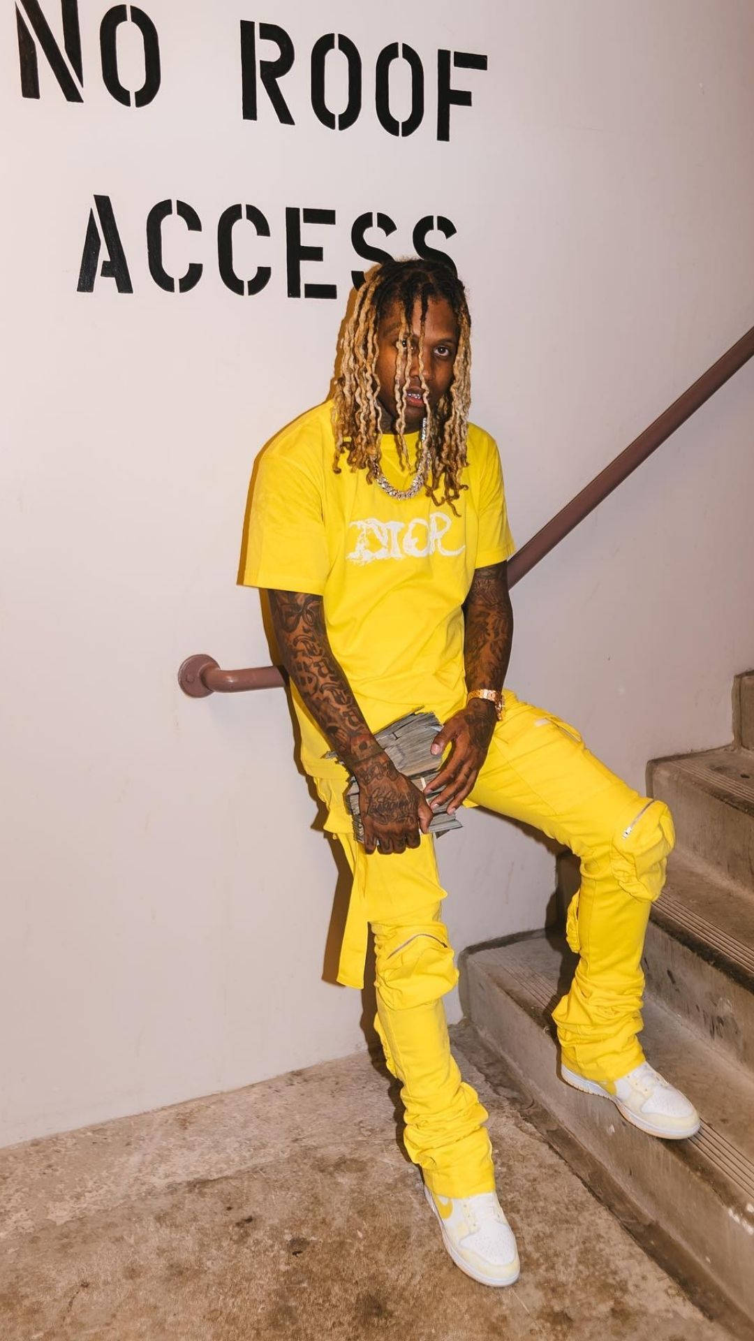 Lil Durk 桌布 壁紙 — 一名身穿亮黃色Dior服裝的男子隨意地坐在混凝土樓梯上，上方有'NO ROOF ACCESS'牆牌。