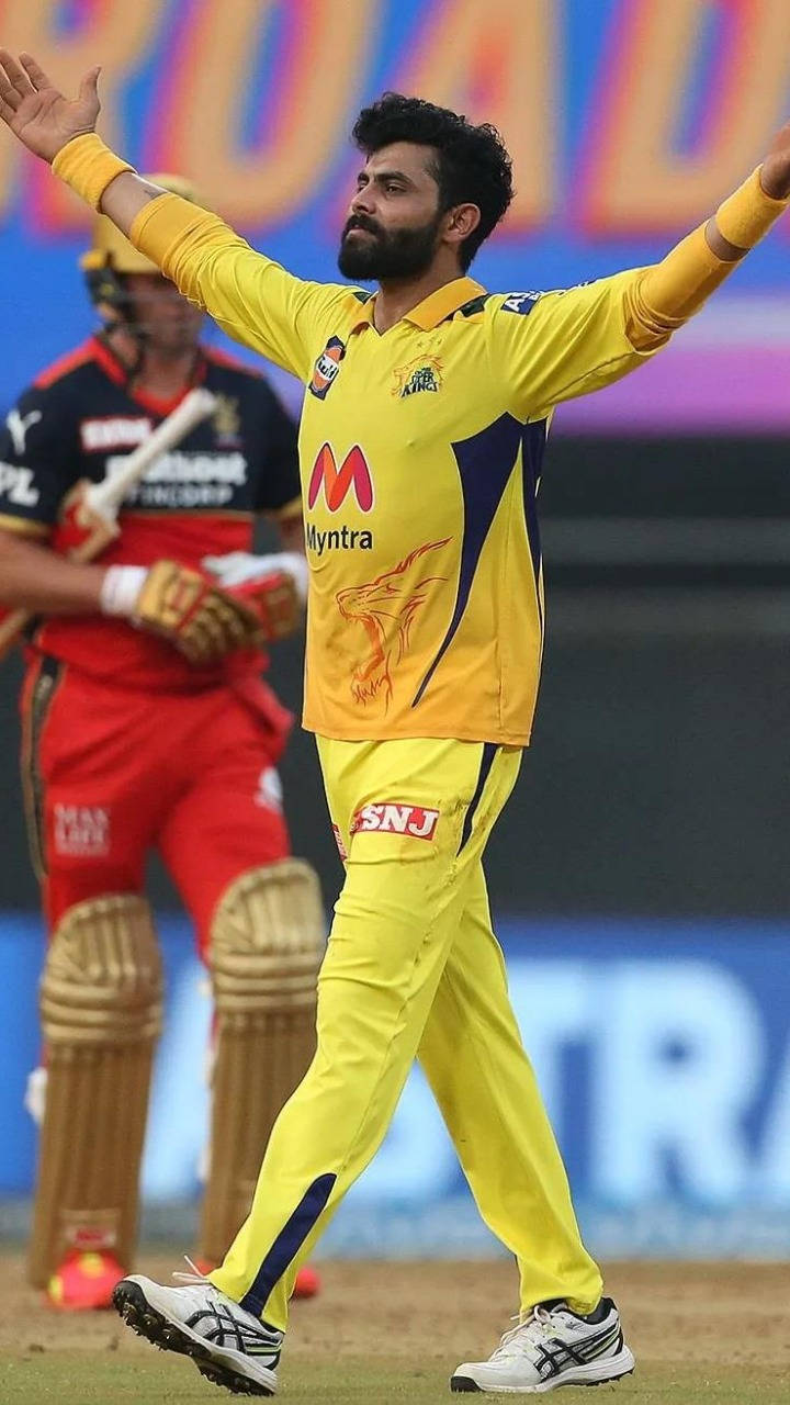 Chennai Super Kings 桌布 壁紙 — 一名身穿亮黃色球衣的板球運動員在球場燈光下，於綠色場地上高舉雙臂慶祝。