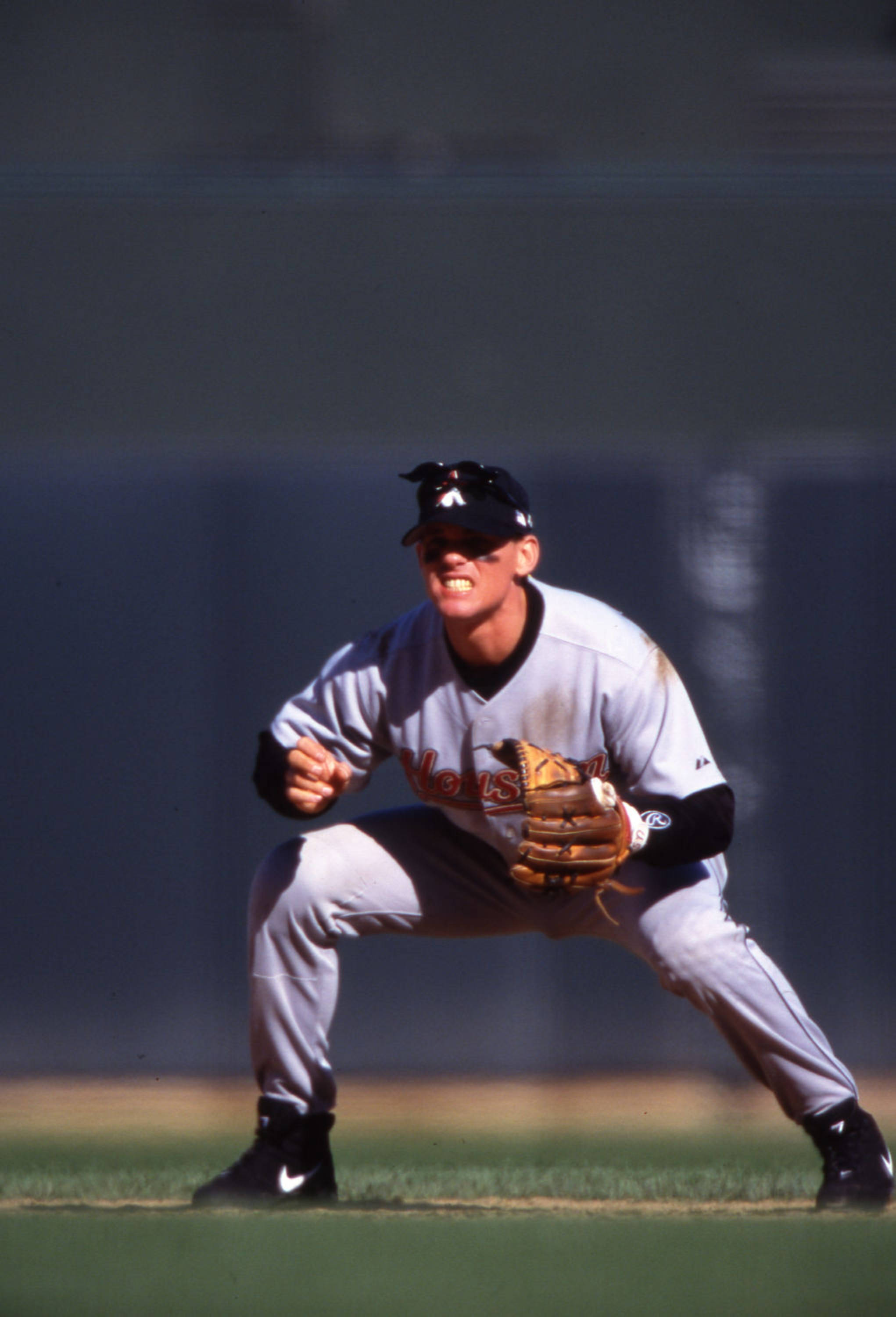 Craig Biggio 桌布 壁紙 — 一名身穿休士頓太空人隊球衣的棒球手在陽光明媚的球場上蹲伏準備，神情專注。
