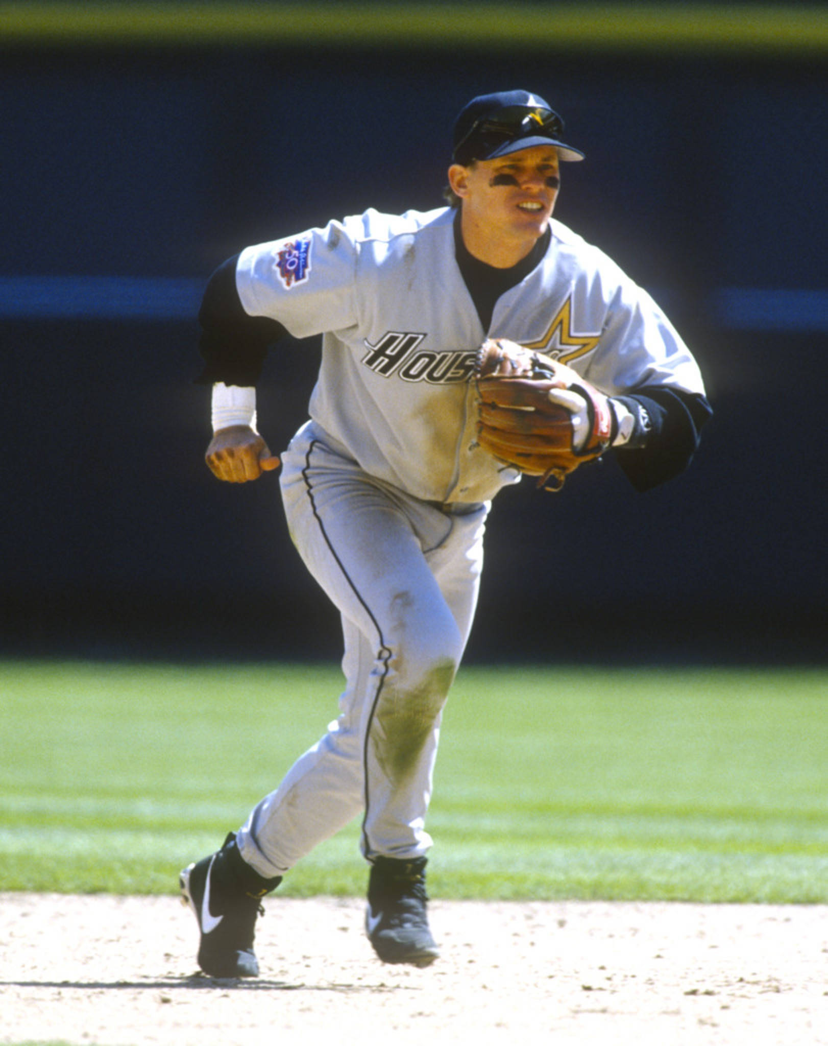 Craig Biggio 桌布 壁紙 — 一名身穿休士頓太空人隊球衣的棒球運動員，在陽光明媚的球場上堅定地衝刺。