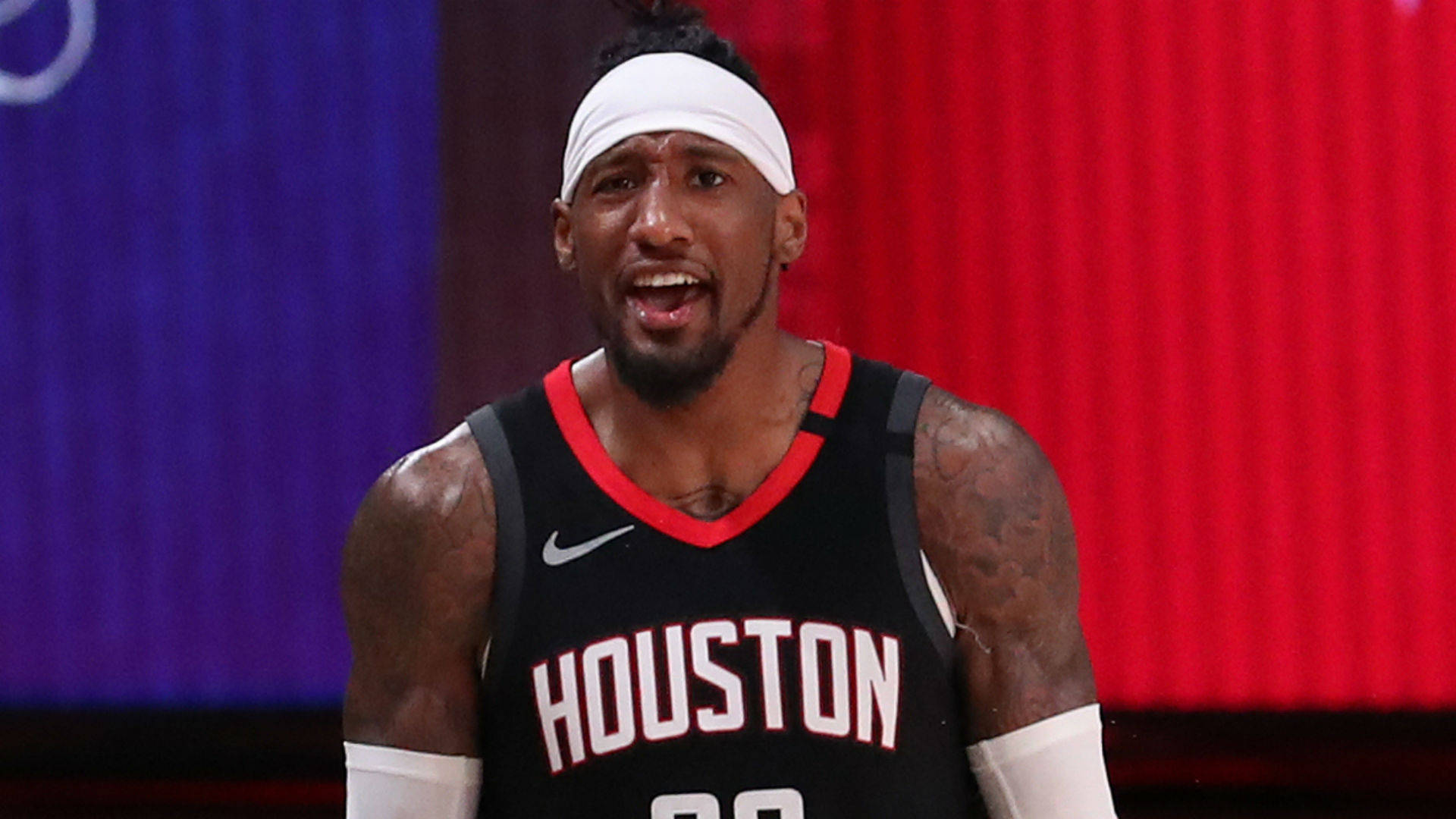 robert covington 桌布 壁紙 — 一名身穿休士頓球衣的籃球運動員在明亮的場館燈光下比賽中激烈地大喊。