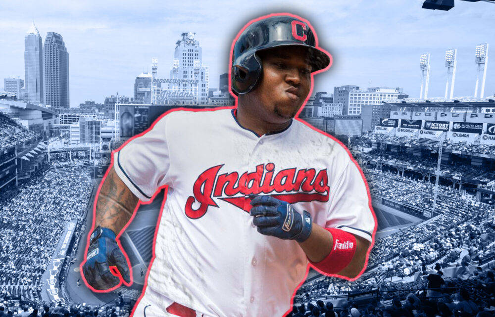 Jose Ramirez 桌布 壁紙 — 一名身穿克里夫蘭印地安人隊球衣的棒球選手，在擠滿觀眾的體育場中奔跑，背景是城市天際線。