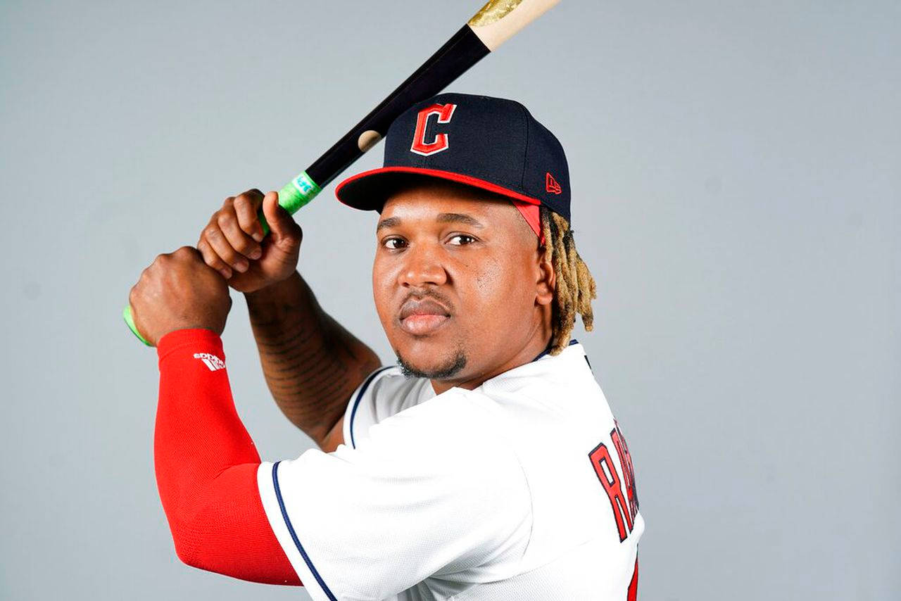 Jose Ramirez 桌布 壁紙 — 一名身穿克里夫蘭球衣的棒球運動員，在純灰色背景前將球棒扛在肩上。