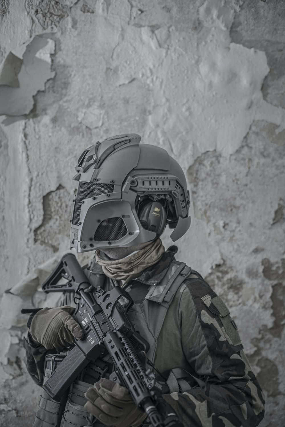soldier 桌布 壁紙 — 一名身穿全套戰術裝備和頭盔的士兵，靠著風化的混凝土牆，手持突擊步槍保持警覺。