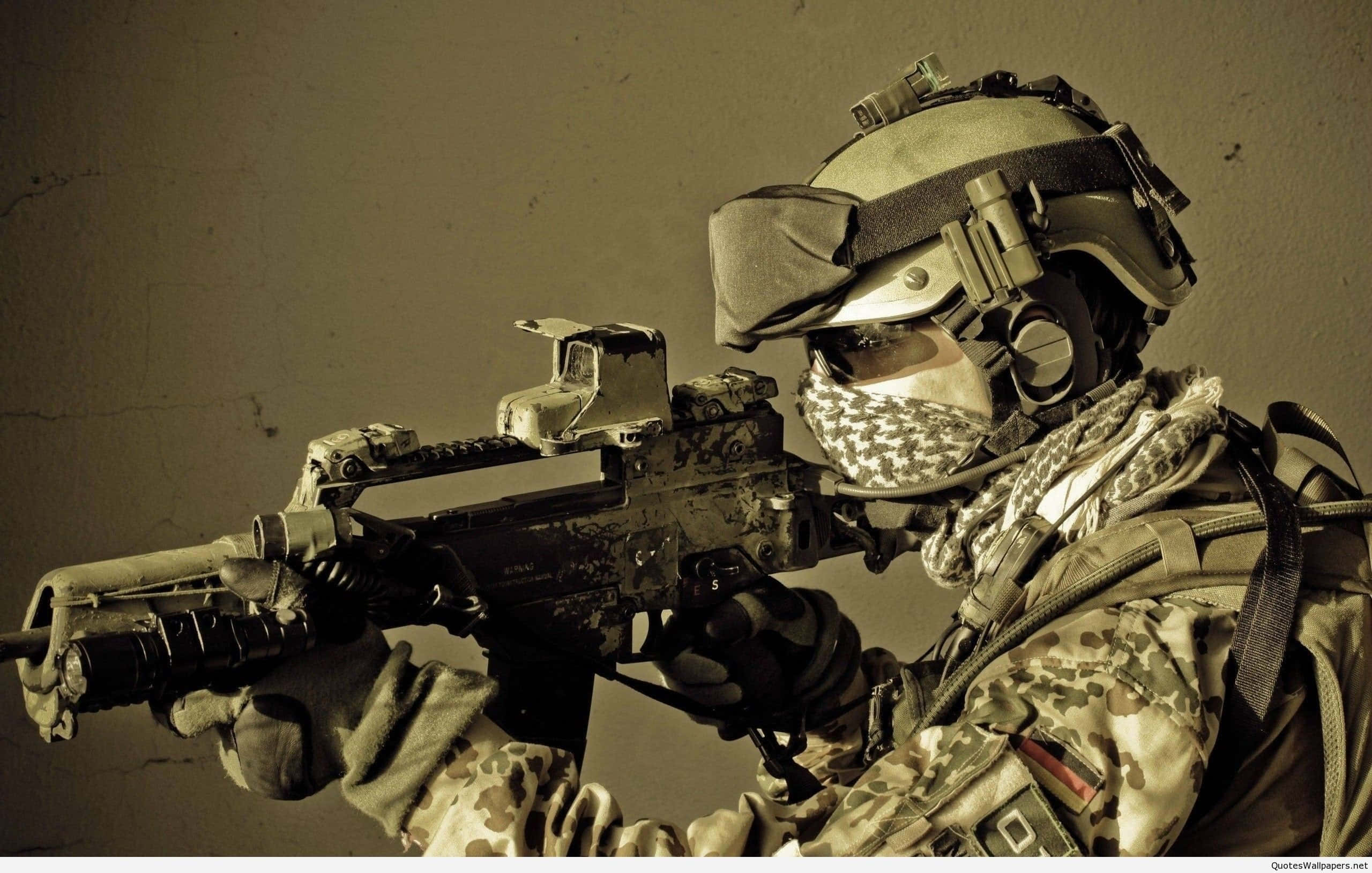 4K Military 桌布 壁紙 — 一名身穿全套戰術裝備的士兵，以強烈的專注力瞄準步槍，背景是柔和的灰褐色牆壁。