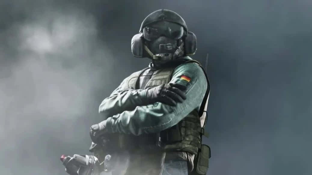 Rainbow Six Siege Jager 桌布 壁紙 — 一名身穿全套戰術裝備的士兵，在煙霧瀰漫的灰色背景下，雙臂交叉，堅定地站立。