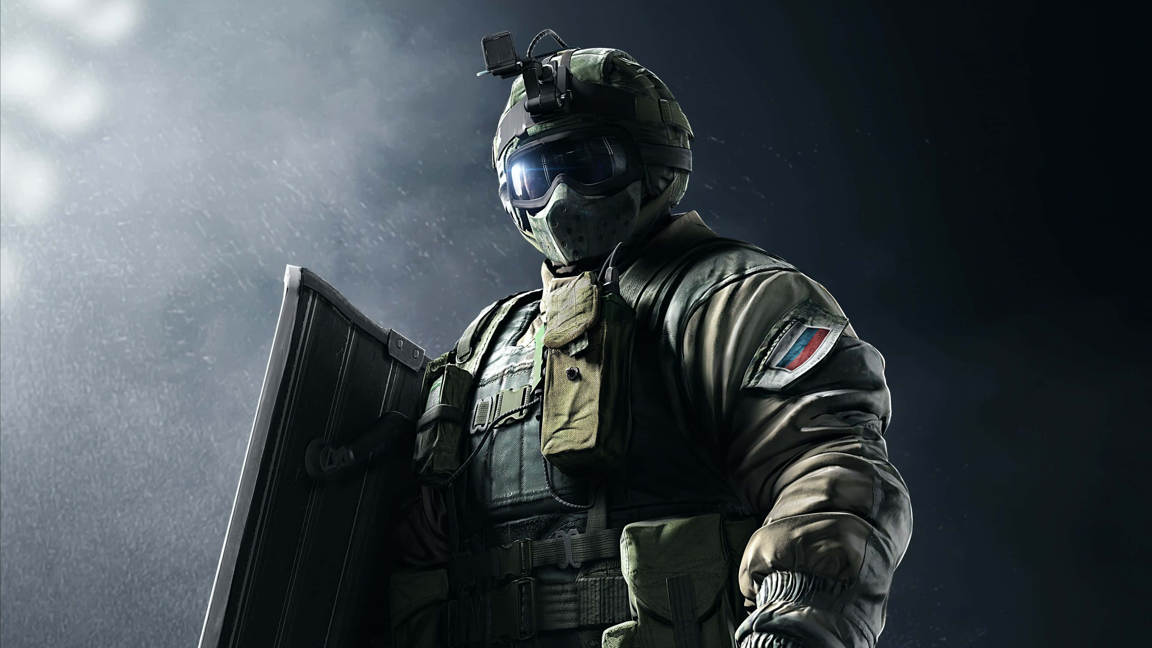Rainbow Six Siege Fuze 桌布 壁紙 — 一名身穿全套戰術裝備的士兵在戲劇性的雨夜燈光下，以陰暗氛圍為背景，手持盾牌。
