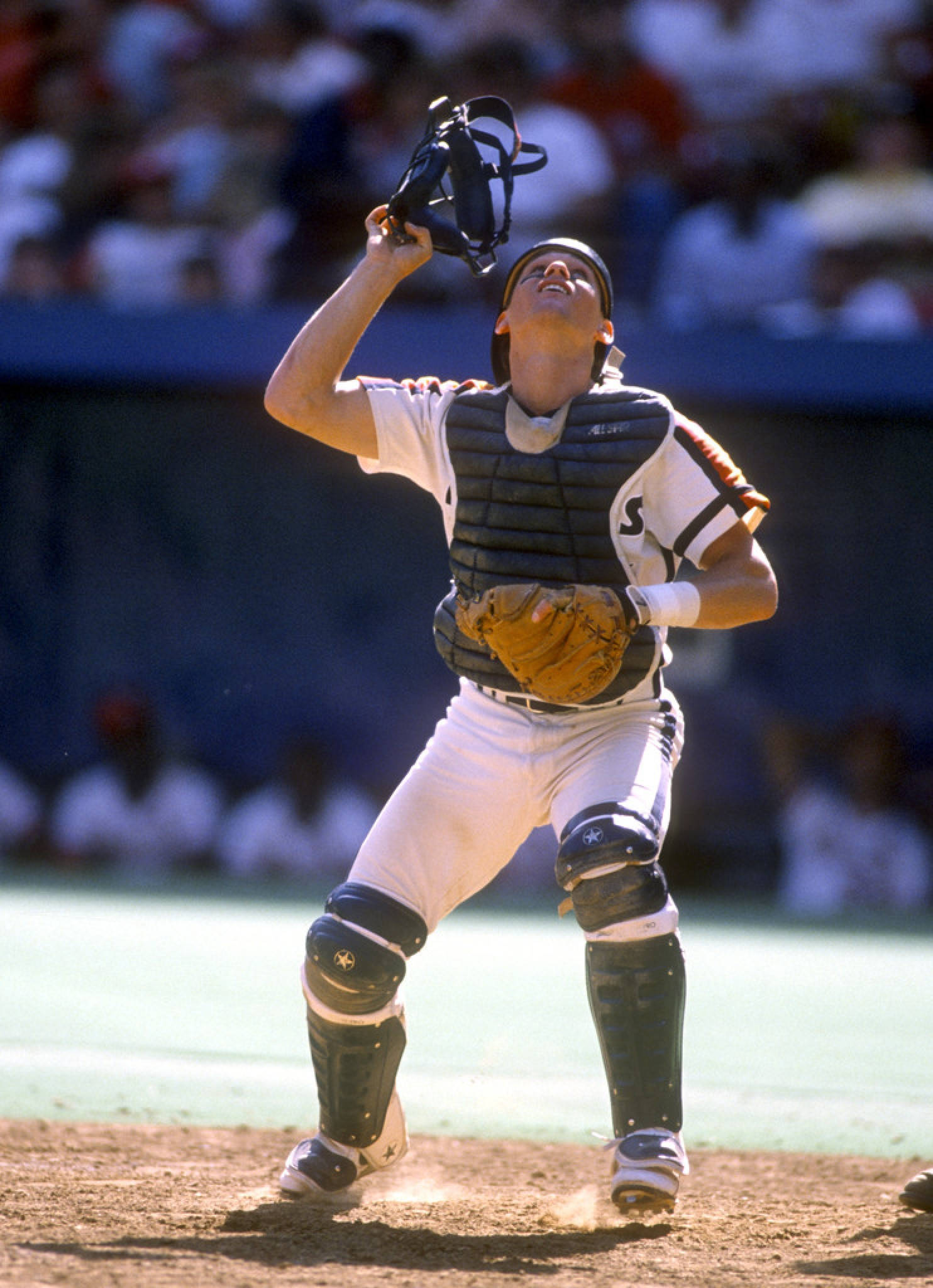 Craig Biggio 桌布 壁紙 — 一名身穿全套裝備的棒球捕手在明亮的日光下站在土墩上，向上舉起他的面罩。