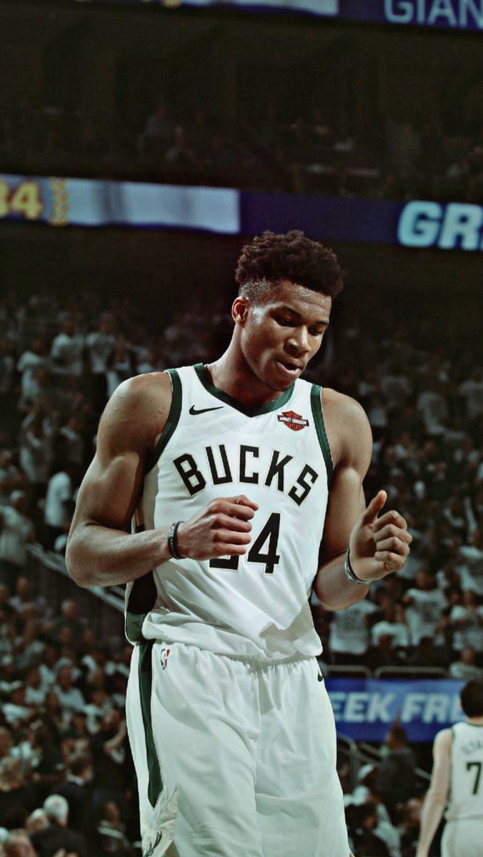 Bucks 桌布 壁紙 — 一名身穿公鹿隊球衣的專注籃球運動員在明亮的場館燈光下於比賽中激烈地做手勢。