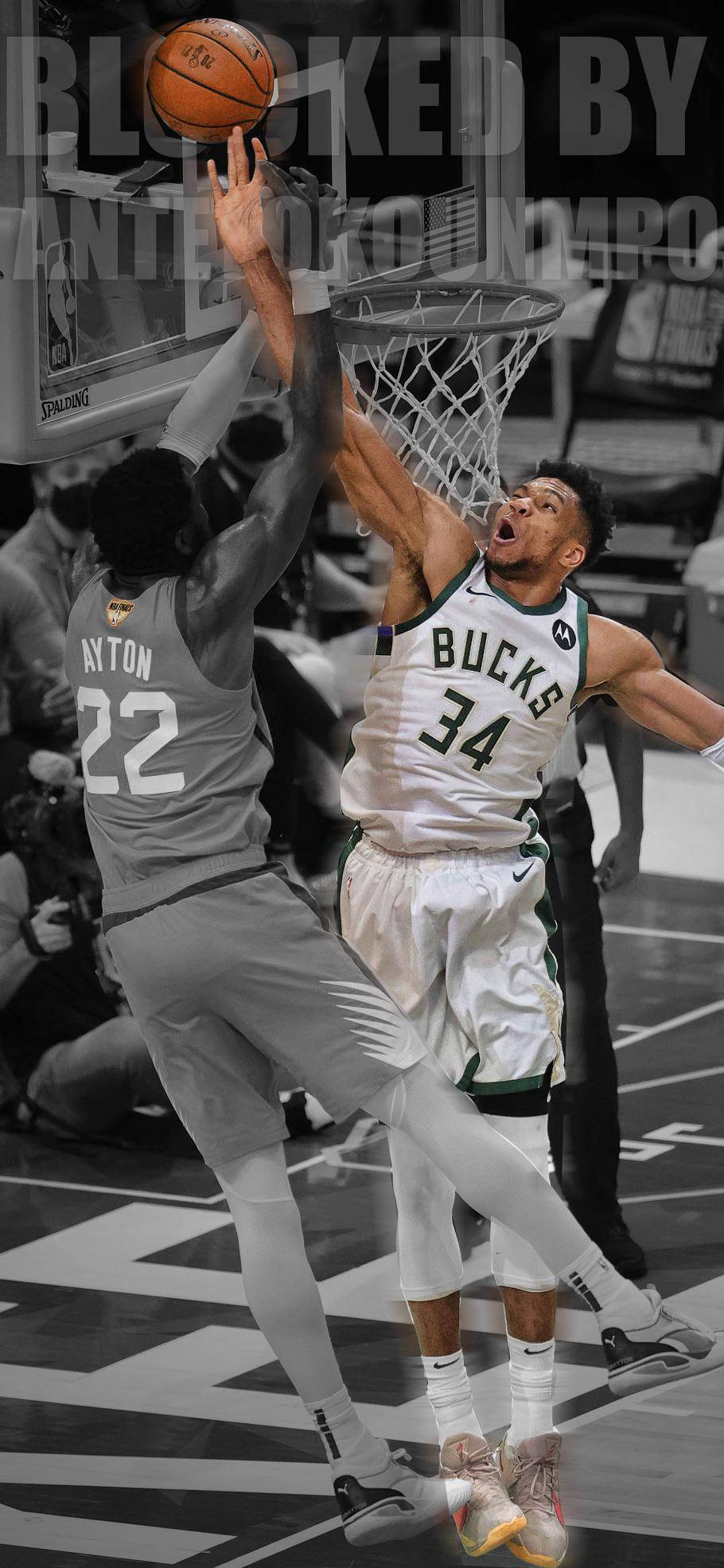 Bucks 桌布 壁紙 — 一名身穿公鹿隊球衣的籃球運動員跳起灌籃，但被一名身穿灰色球衣的防守球員封阻。