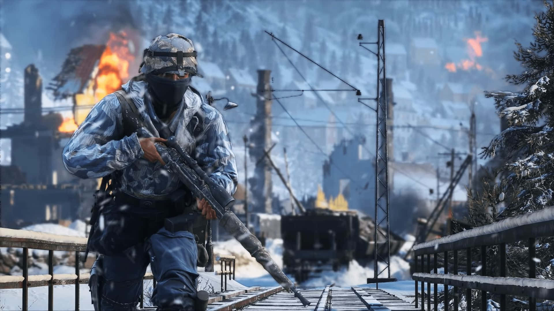 1080p Battlefield V 桌布 壁紙 — 一名身穿冬季迷彩服的士兵在積雪的鐵路橋上前進，遠處的建築物在白雪覆蓋的山城燃燒。