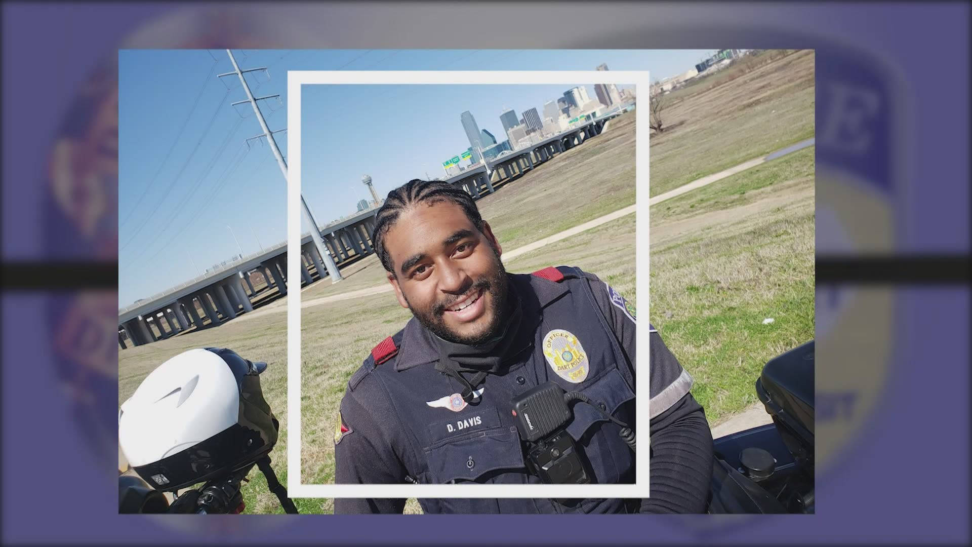 微笑 桌布 壁紙 — 一名身穿制服、面帶微笑的警察在機車旁自拍，背景是城市天際線和橋樑，天空湛藍清澈。