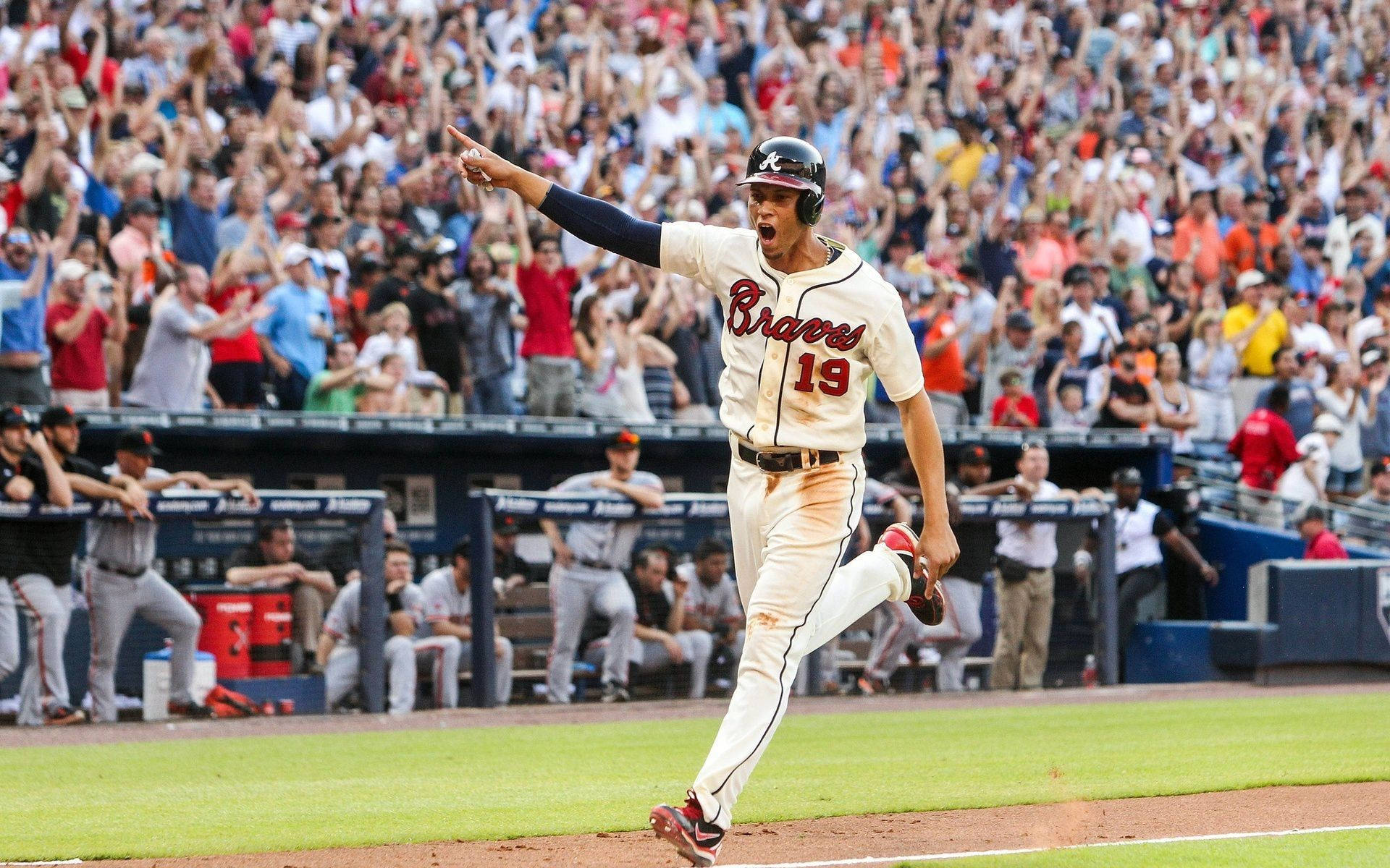 Braves 桌布 壁紙 — 一名身穿勇士隊球衣的棒球選手高舉雙臂慶祝全壘打，球迷在球場歡呼。