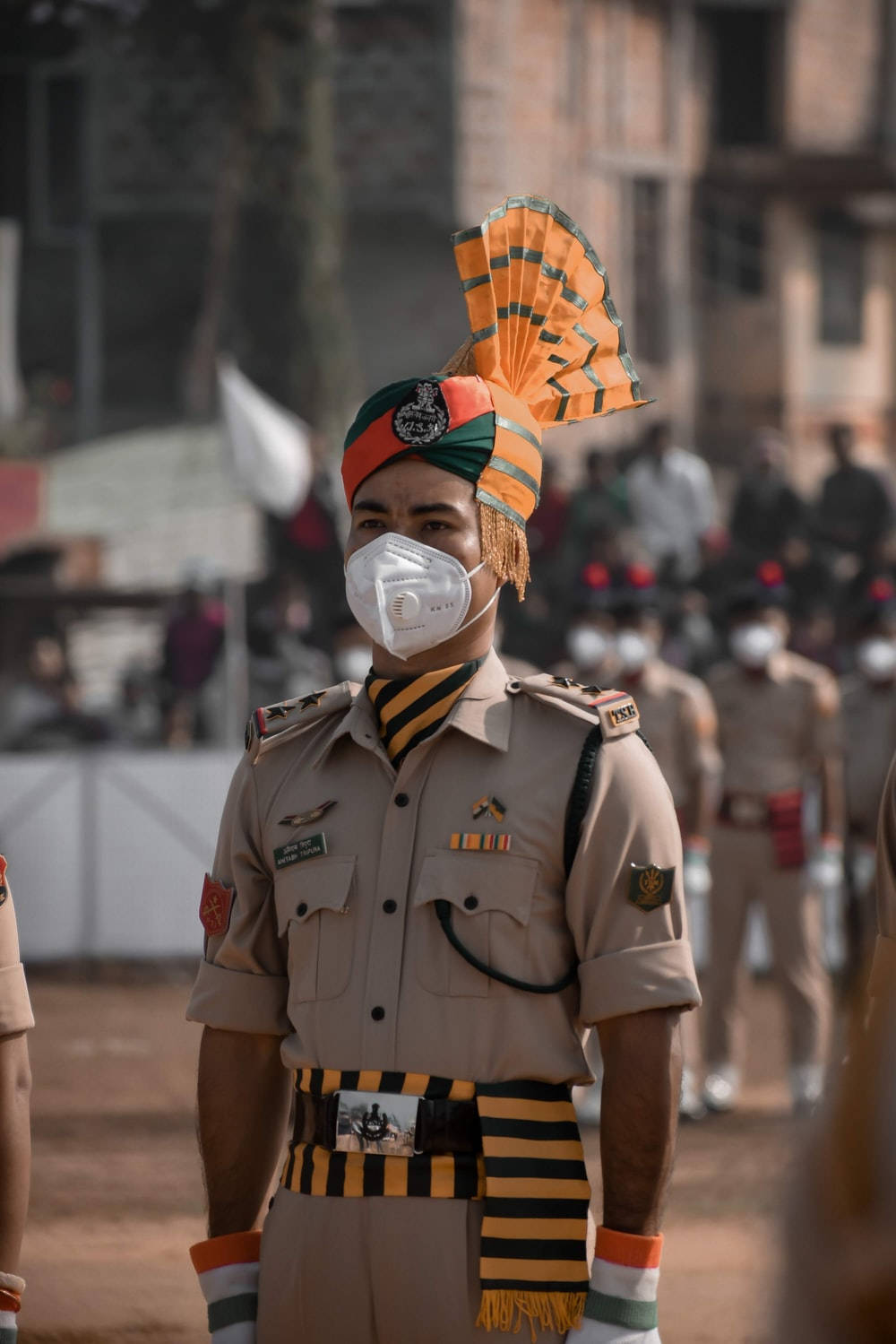 Indian 桌布 壁紙 — 一名身穿卡其色制服和彩色頭巾的士兵在遊行期間戴著白色口罩立正。