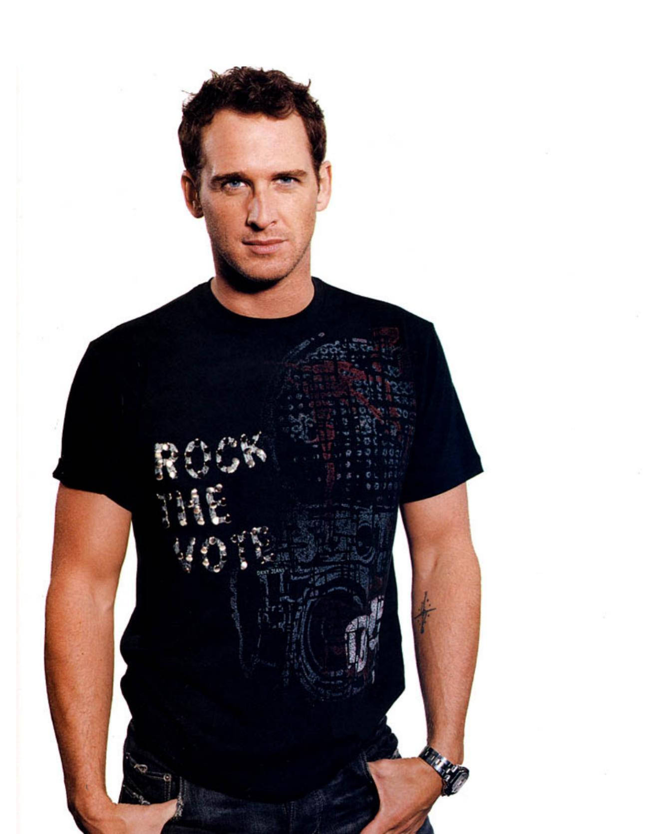 Celebrity 桌布 壁紙 — 一名身穿印有「rock the vote」圖案黑色T恤的男子，自信地站在純白色背景前。
