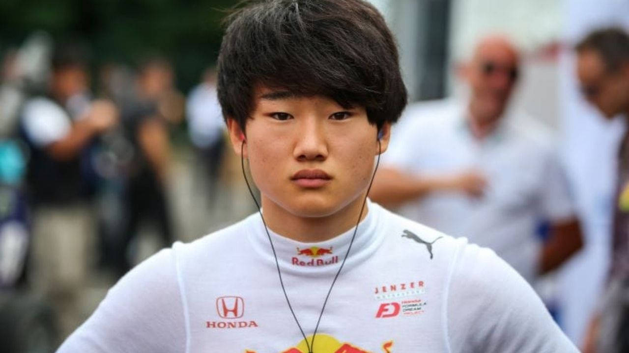 Puma 桌布 壁紙 — 一名身穿印有Red Bull Honda標誌的白色賽車隊服的年輕亞洲男子，表情嚴肅地直視鏡頭。