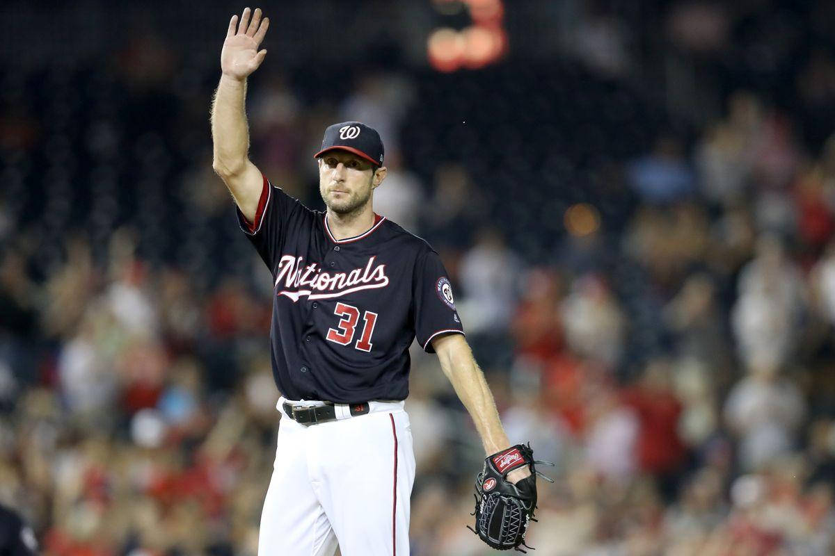 Max Scherzer 桌布 壁紙 — 一名身穿國民隊球衣的棒球選手在球場燈光下向球迷揮手，身後是模糊的人群。