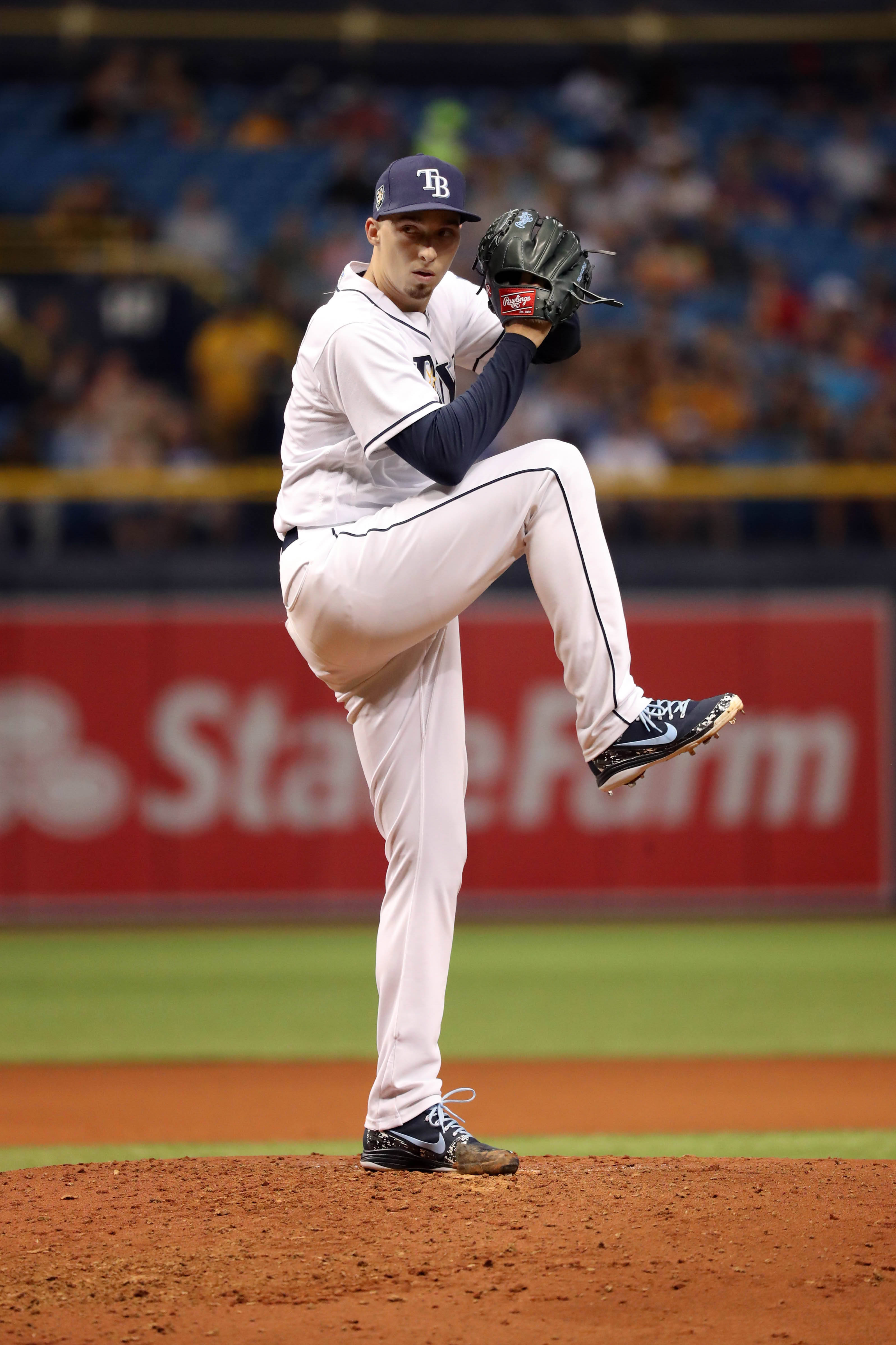 Blake Snell 桌布 壁紙 — 一名身穿坦帕灣球衣的棒球投手在燈光照射的投手丘上投球，背景是模糊的球場人群。