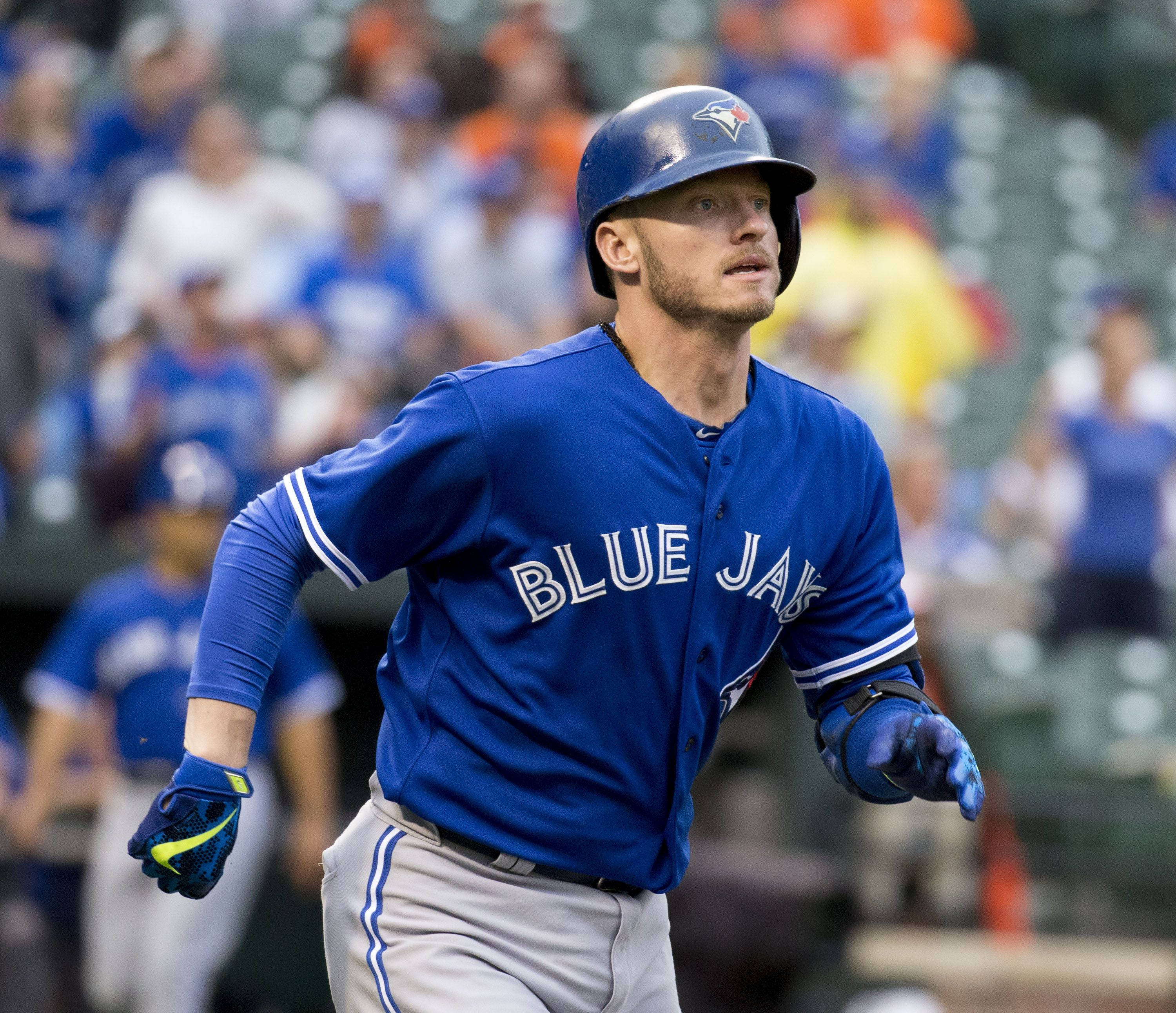 MLB 桌布 壁紙 — 一名身穿多倫多藍鳥隊藍色球衣的棒球運動員，在陽光明媚的球場上專注地衝刺。