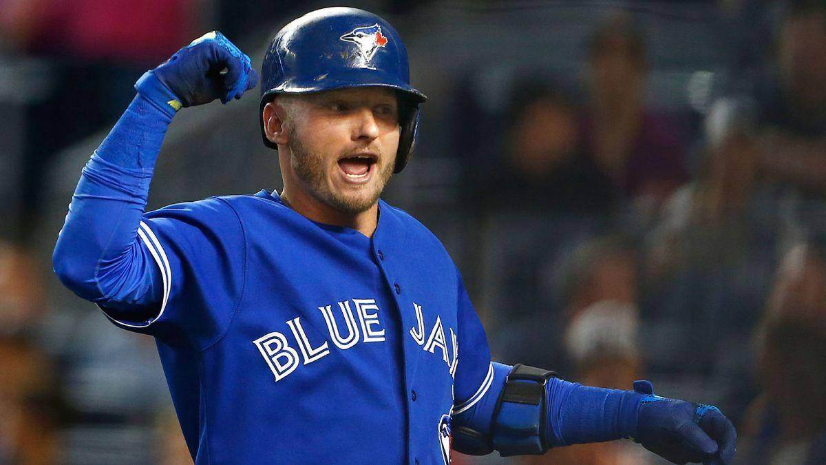 MLB 桌布 壁紙 — 一名身穿多倫多藍鳥隊藍色球衣的棒球運動員在夜間比賽中，在球場燈光下舉起拳頭慶祝。