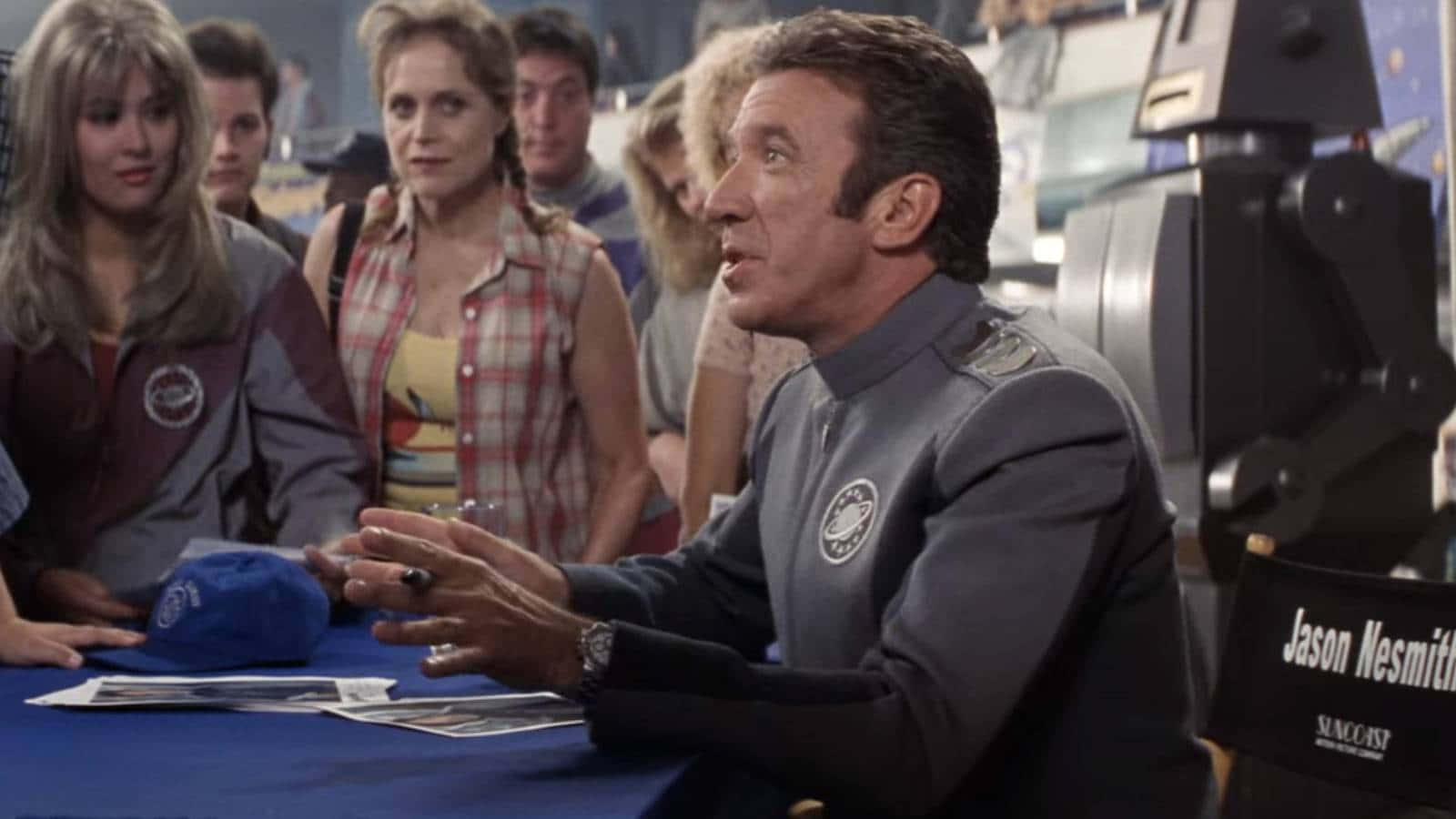 Galaxy Quest 桌布 壁紙 — 一名身穿太空總署制服的男人在粉絲活動中簽名，人群圍觀。