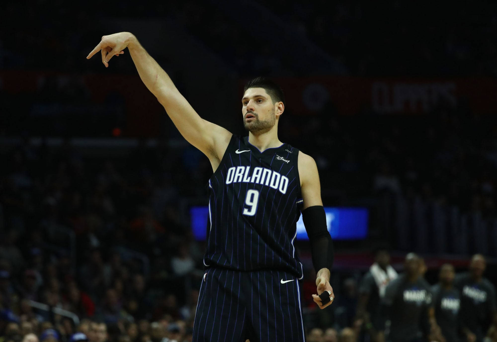 NBA 桌布 壁紙 — 一名身穿奧蘭多球衣的籃球運動員在場館燈光下比賽期間向上指。