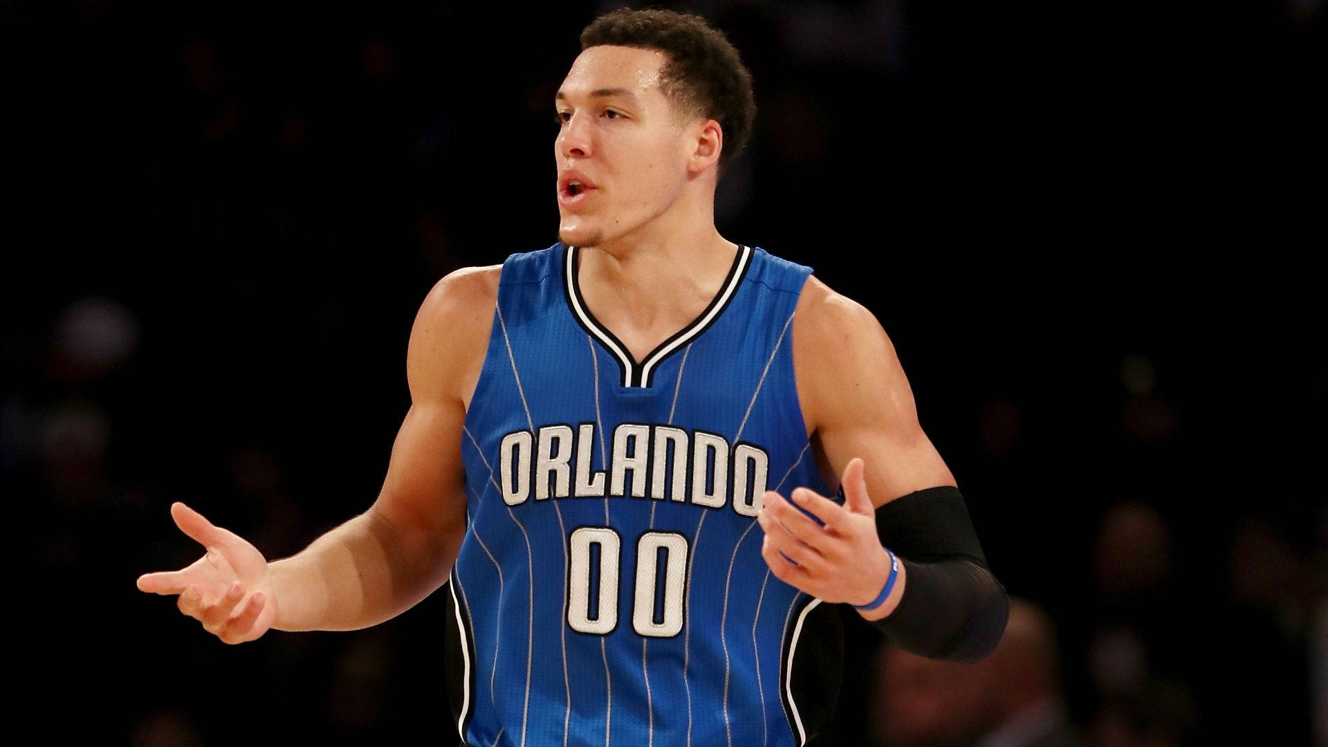 aaron gordon 桌布 壁紙 — 一名身穿奧蘭多球衣的籃球運動員在明亮的場館燈光下比賽時用雙手做手勢。