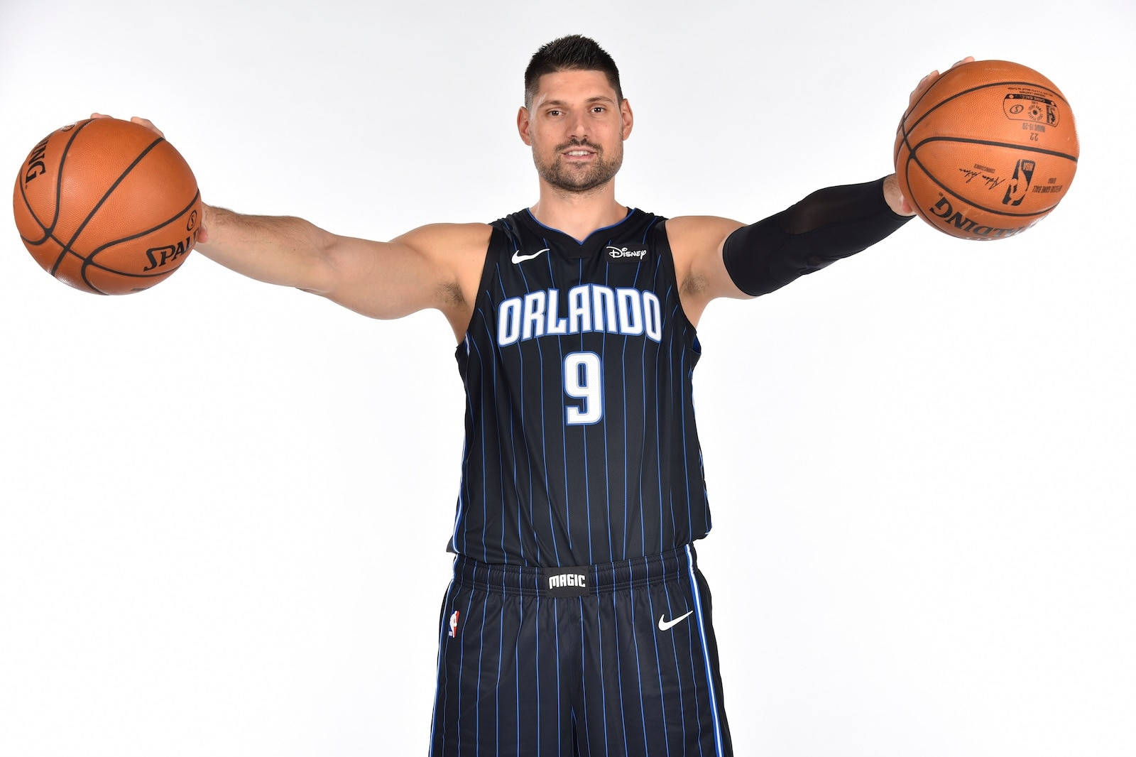 NBA 桌布 壁紙 — 一名身穿奧蘭多魔術隊球衣的籃球運動員，在純白色背景前伸出雙手各持一個籃球。
